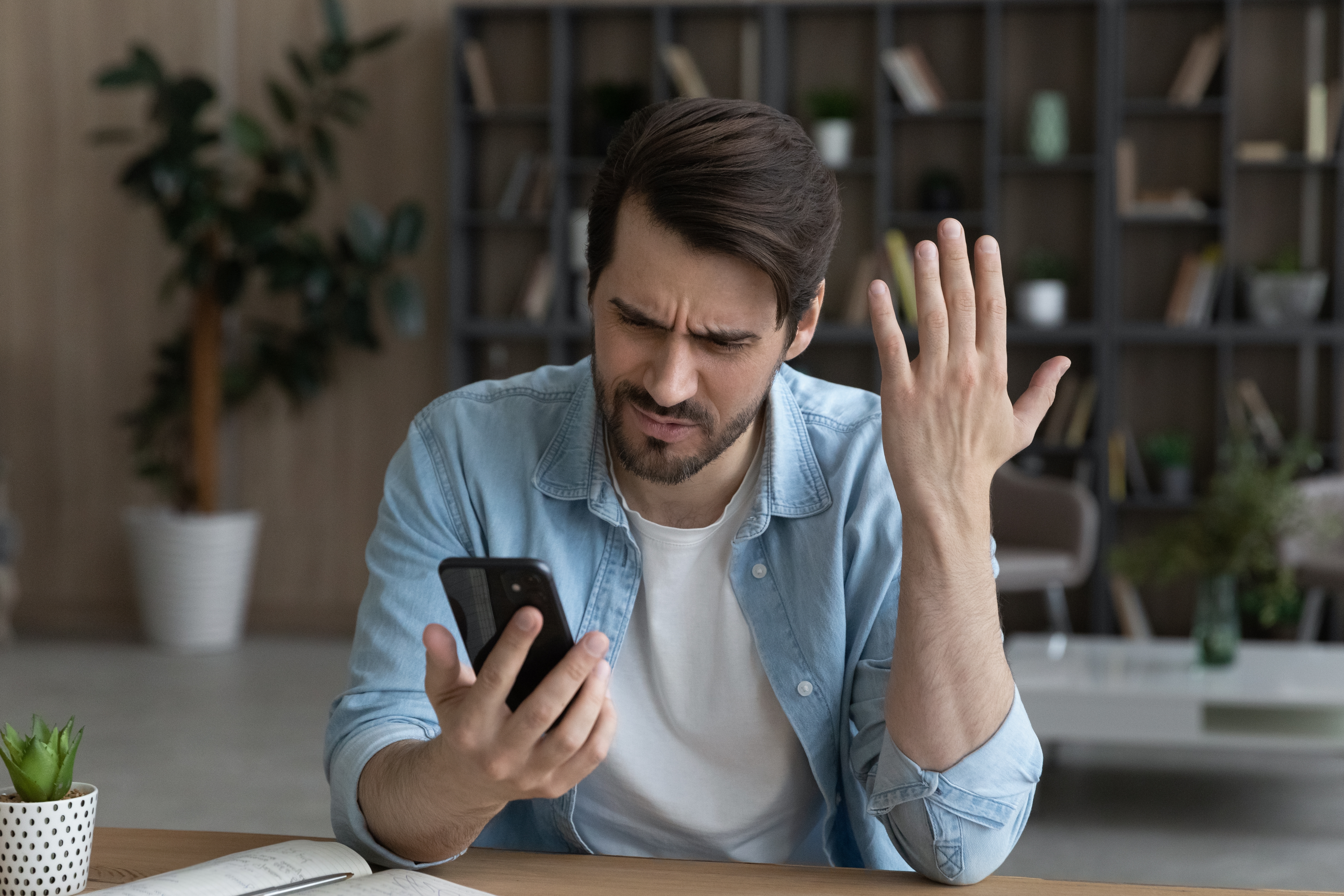 Un homme en colère qui regarde un téléphone | Source : Shutterstock
