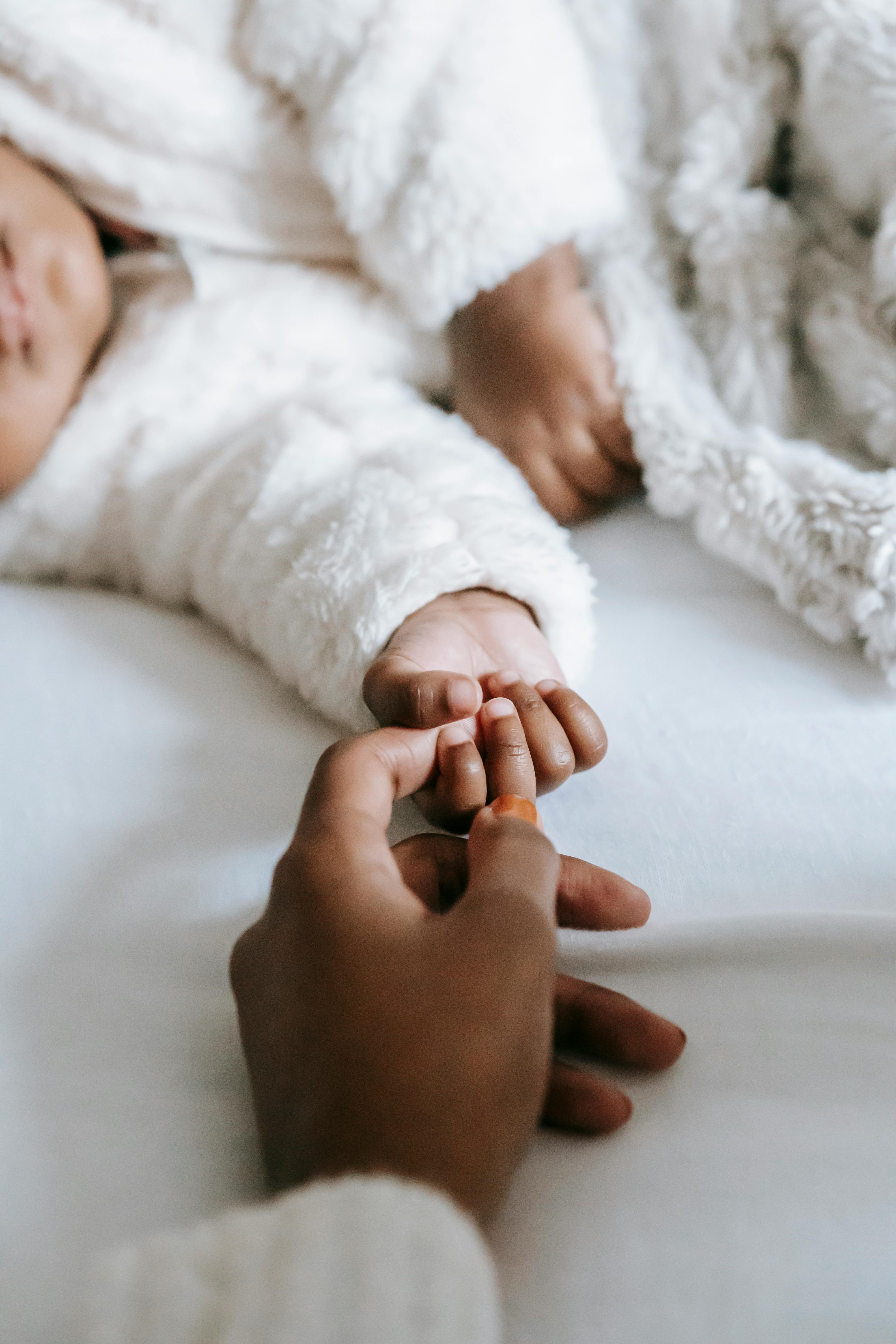 La main d'une femme touchant la main d'un bébé | Source : Pexels