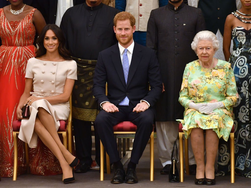 Meghan, la duchesse de Sussex, le prince Harry, le duc de Sussex et la reine Elizabeth II à la cérémonie de remise des prix des jeunes leaders de la Reine au Palais de Buckingham | Photo : Getty Images