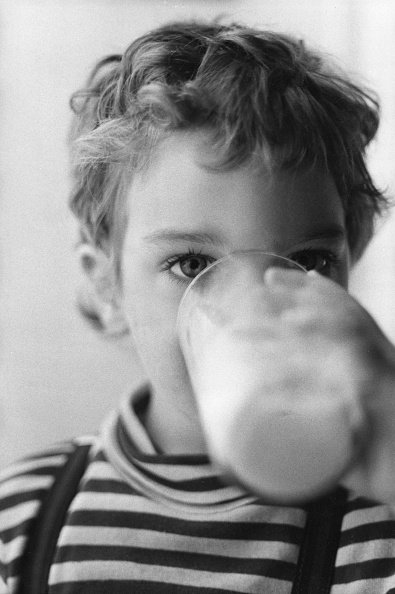 Enfant buvant un verre de lait, circa 1980, France. |Photo : Getty Images