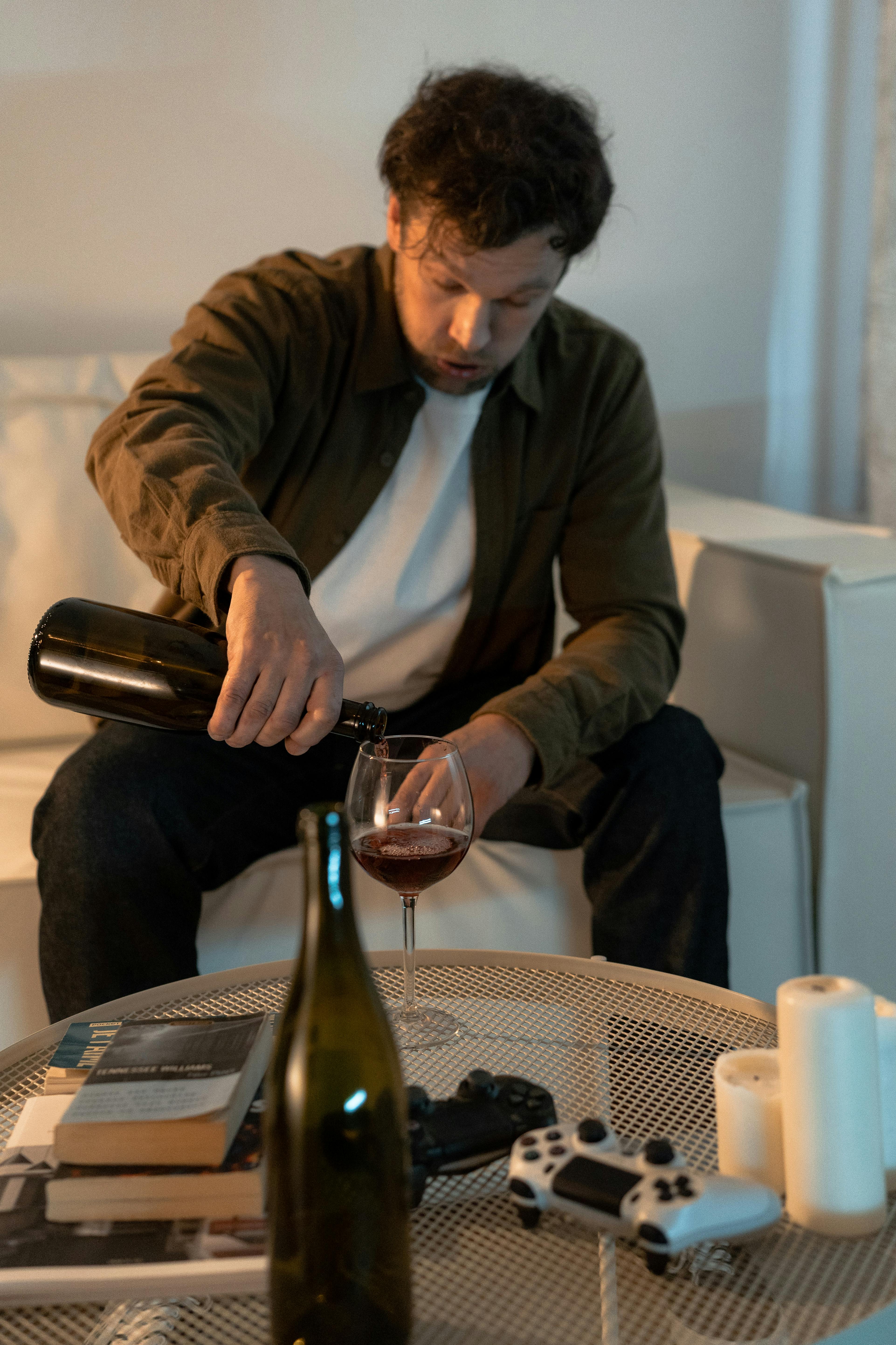 Un homme ivre se verse du vin | Source : Pexels