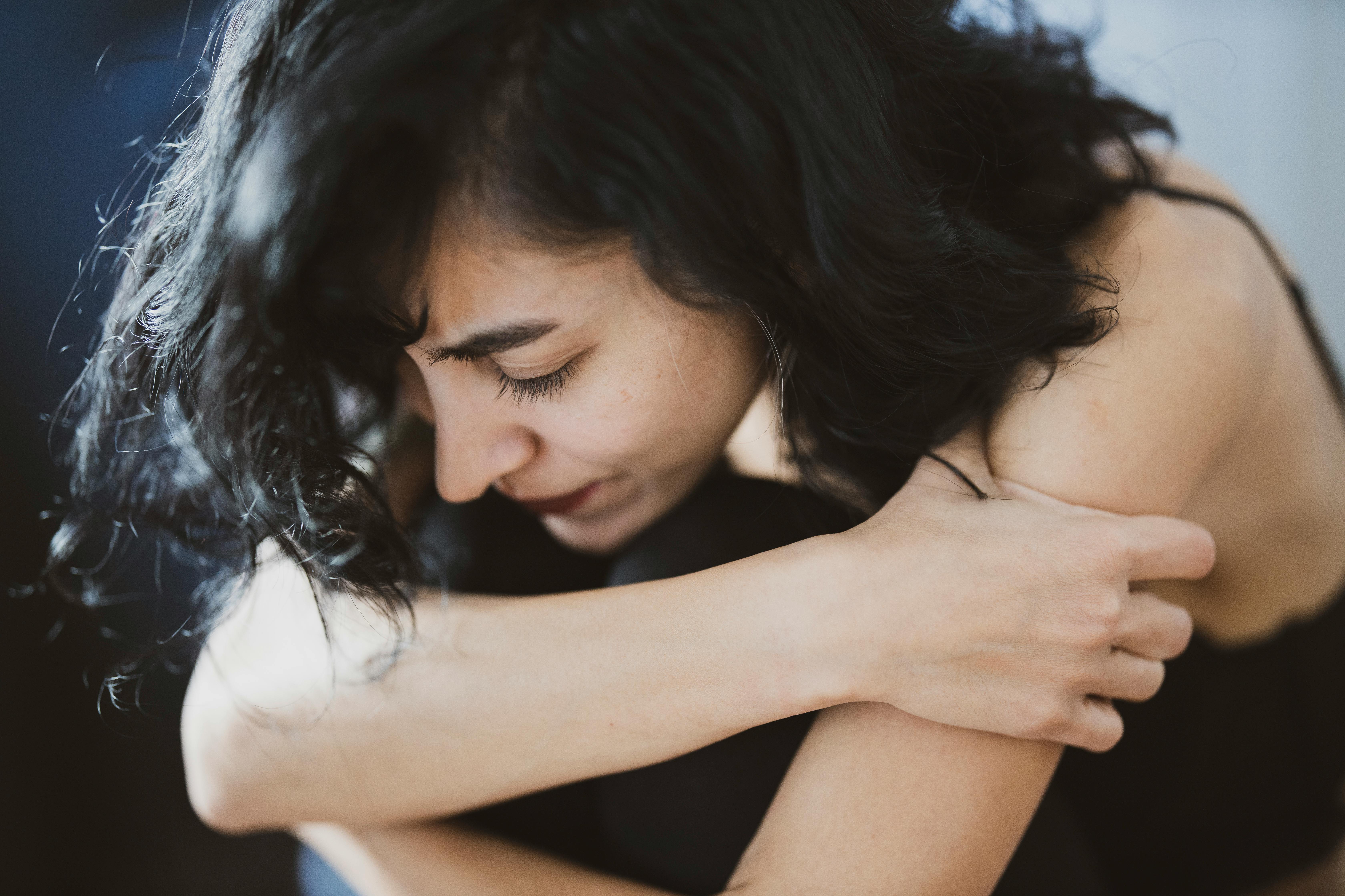 Une femme triste qui se serre dans ses bras | Source : Pexels