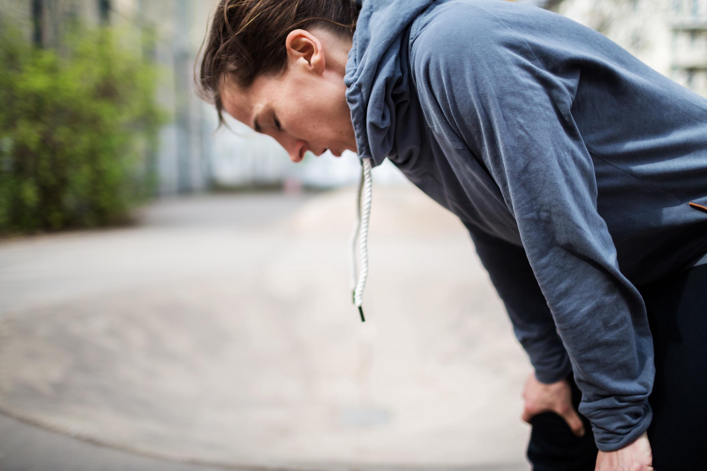 Femme épuisée penchée en avant, les mains sur les genoux, semblant fatiguée | Source : Getty Images