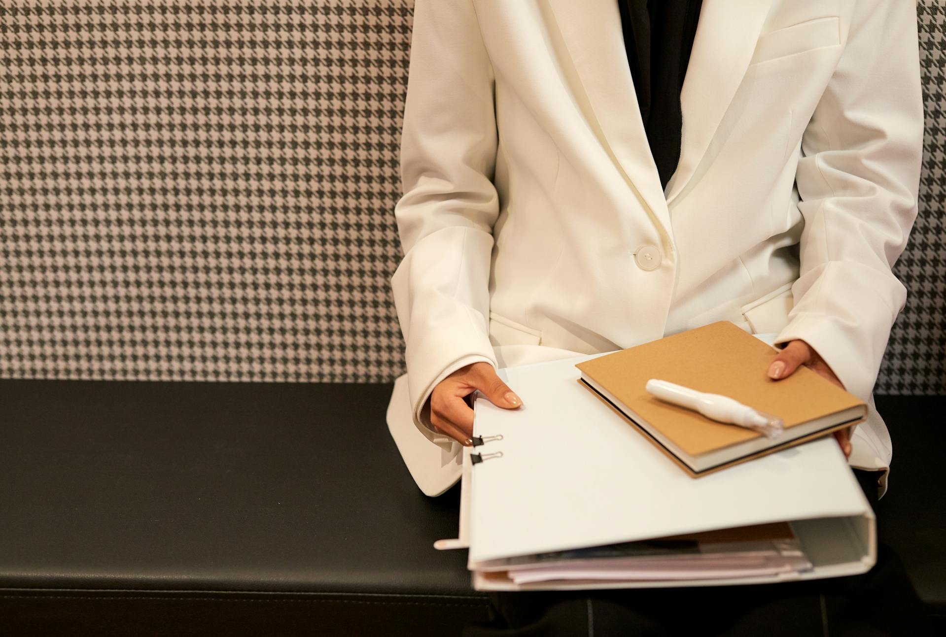 Une femme en blouse blanche tenant un dossier de documents | Source : Pexels