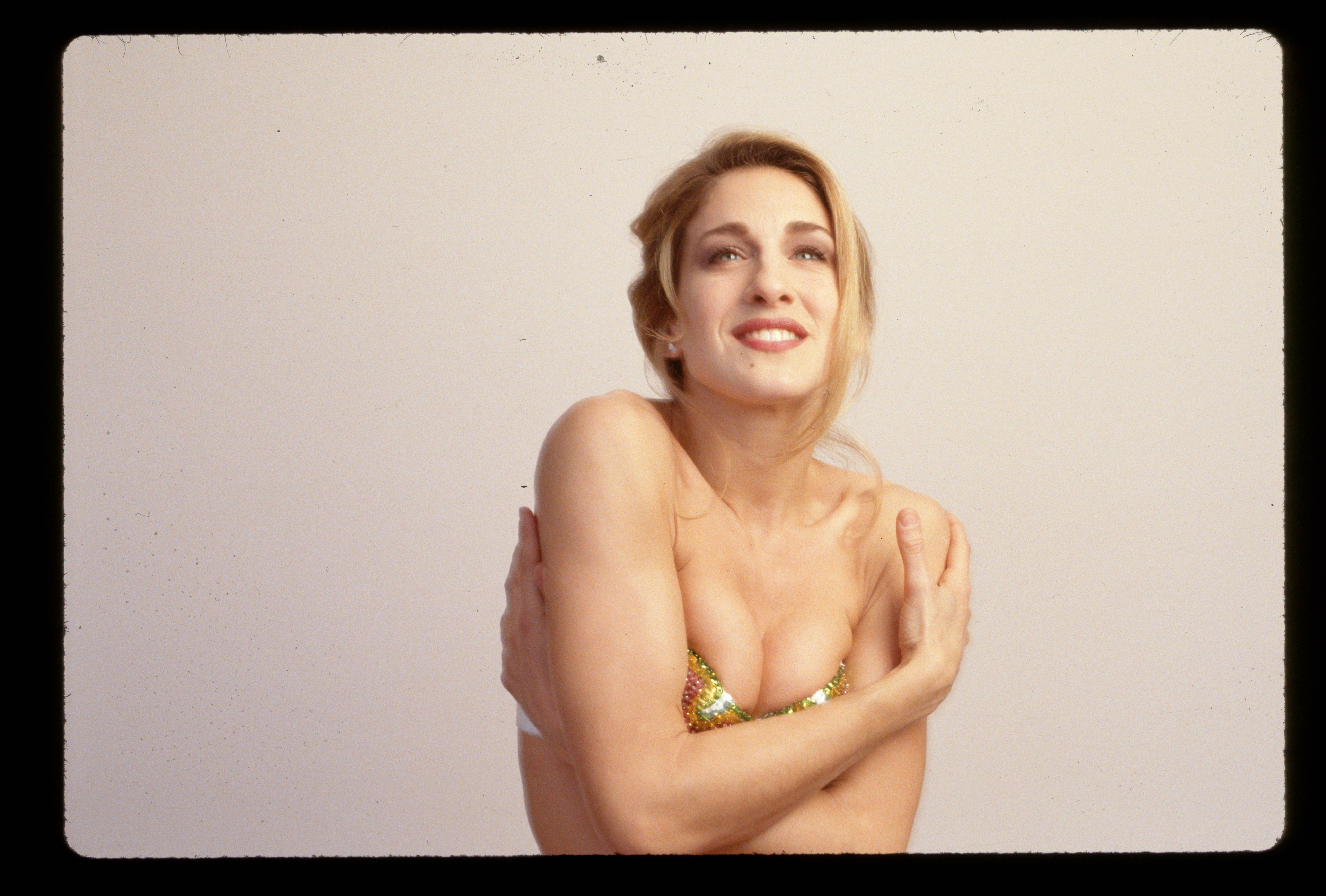 Sarah Jessica Parker est représentée taille haute, les bras croisés devant elle dans un haut de bikini à paillettes en 1990. | Source : Getty Images