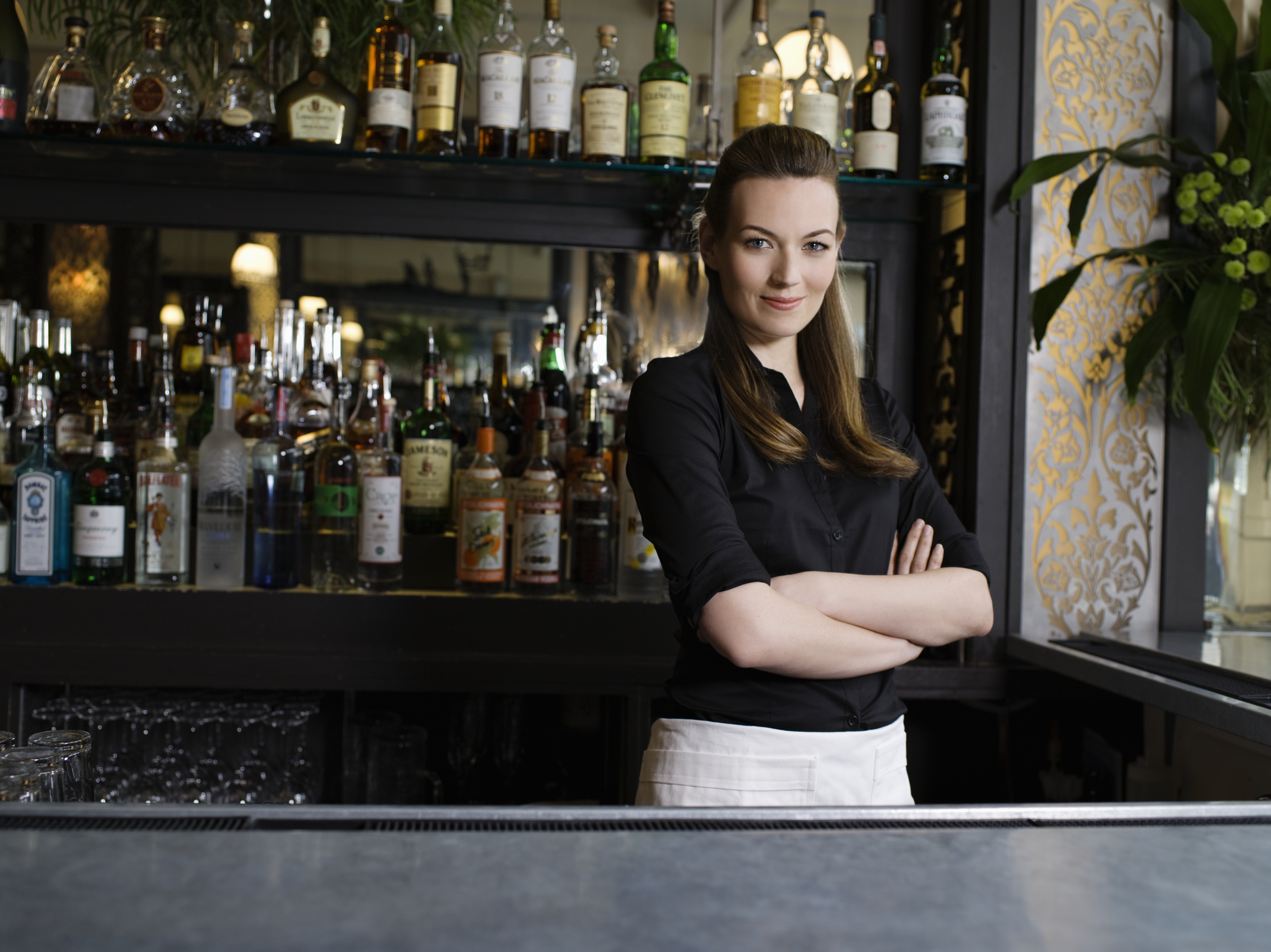 Une barmaid confiante se tenant derrière le bar | Source : Getty Images