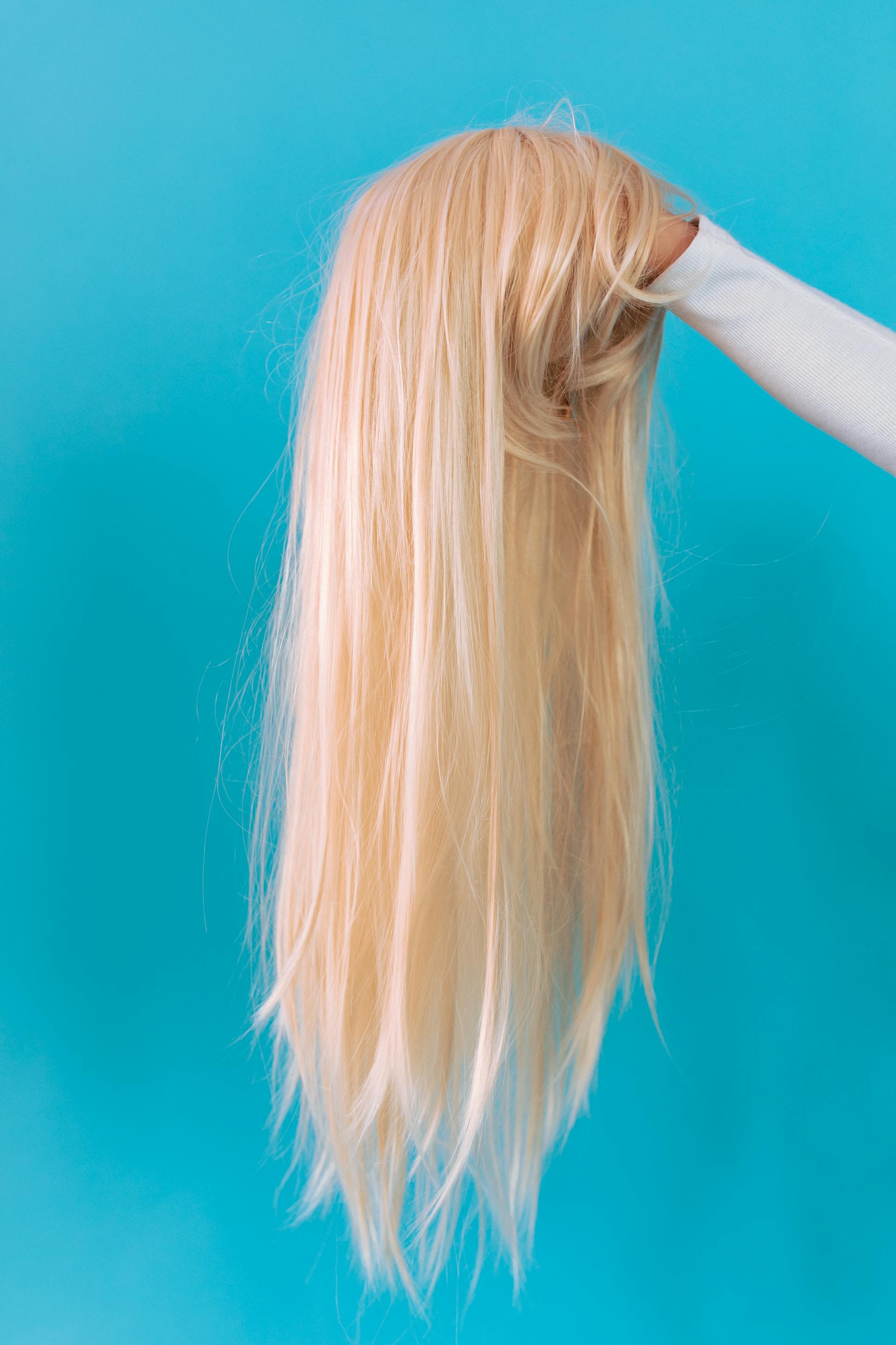 Femme tenant une perruque blonde | Source : Pexels