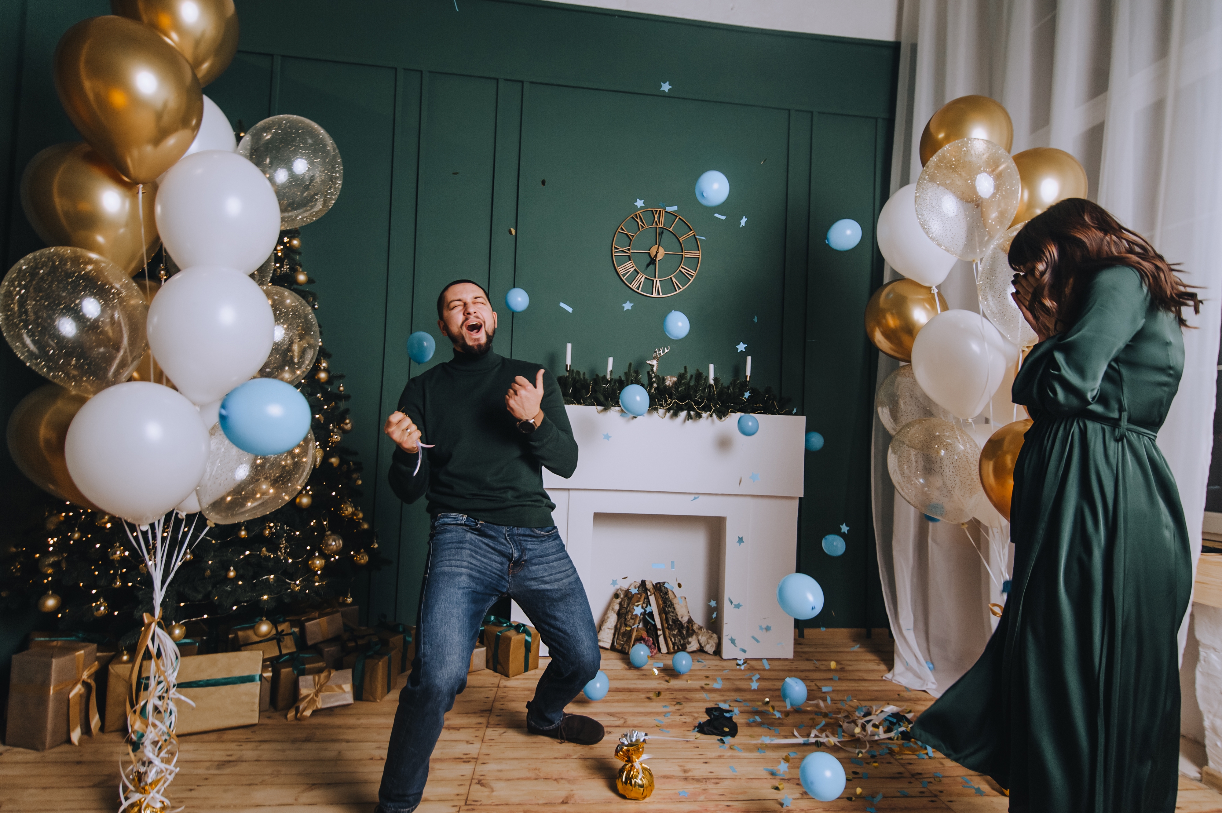 Un homme entouré de ballons bleus célébrant avec enthousiasme | Source : Shutterstock