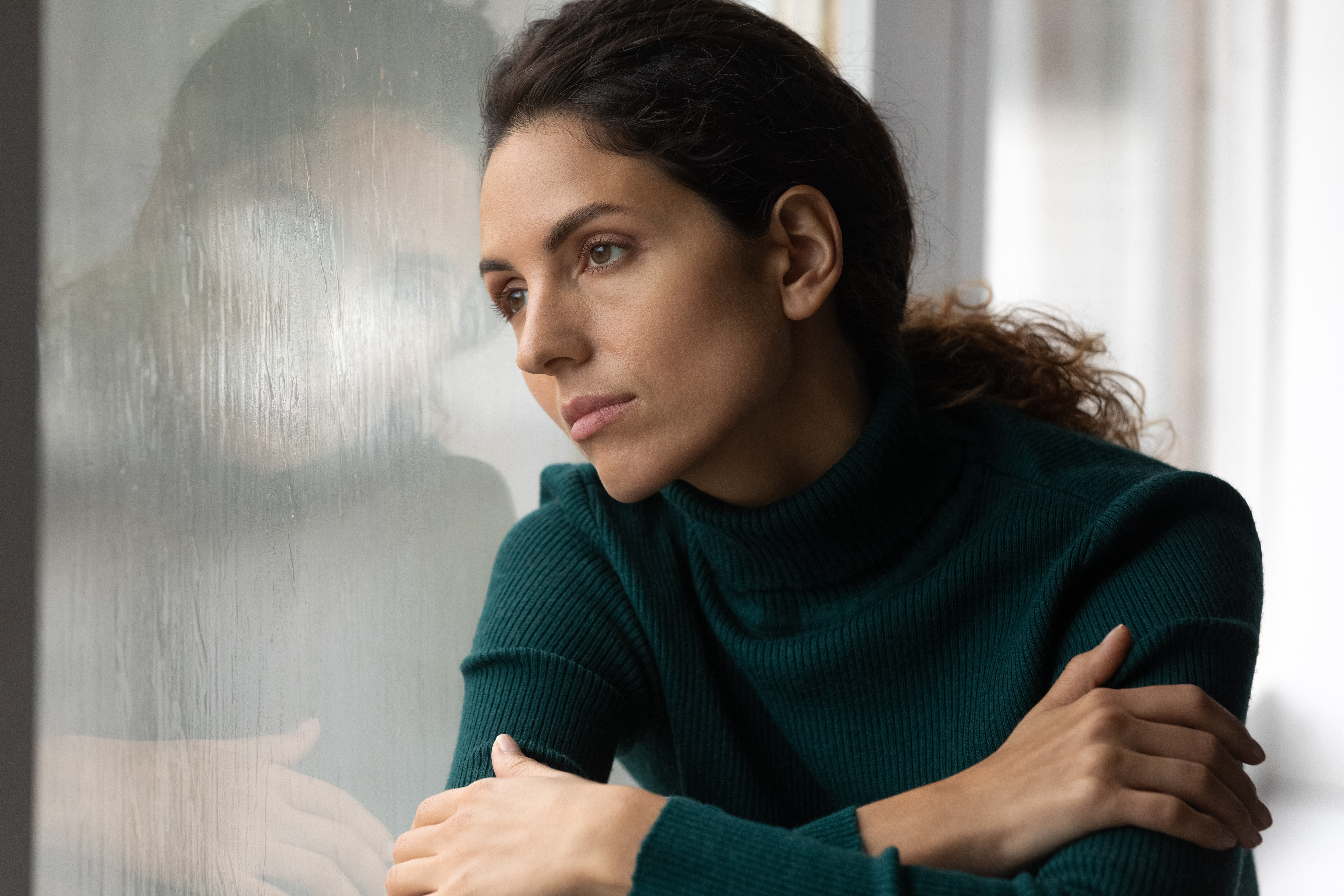 Une femme regardant par une vitre | Source : Shutterstock