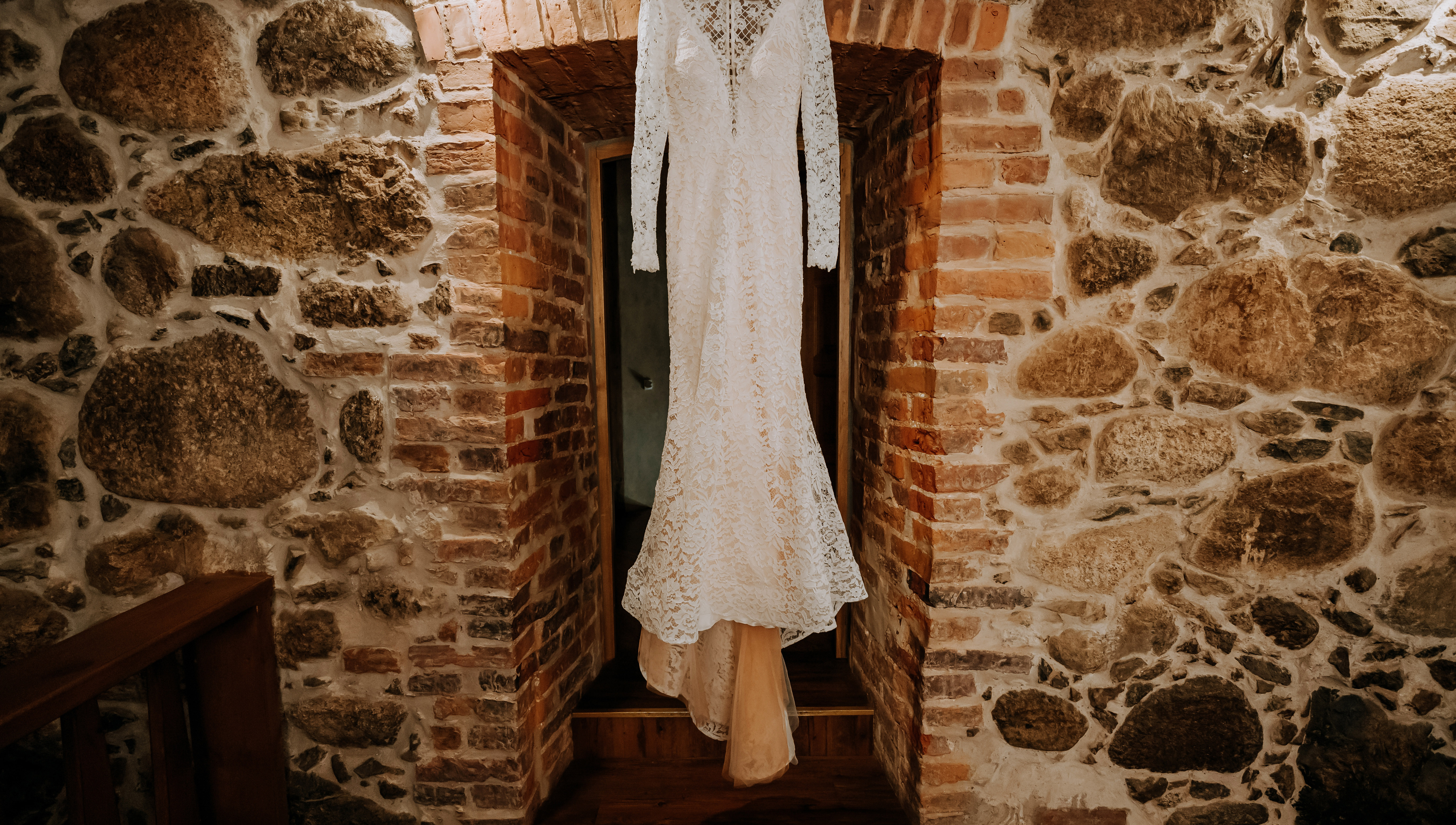 Une robe de mariée suspendue devant un mur de pierre | Source : Shutterstock