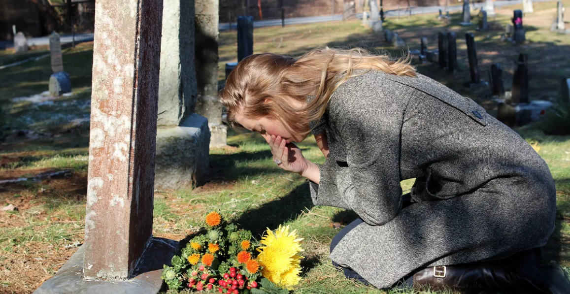 Femme en deuil sur la tombe | Source : Shutterstock