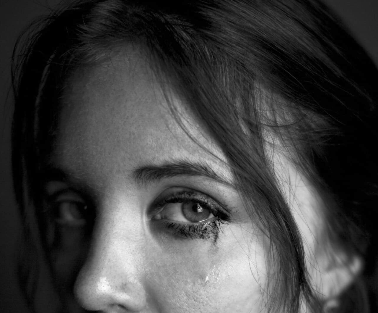Prise de vue en niveaux de gris des yeux larmoyants d'une femme triste | Source : Pexels