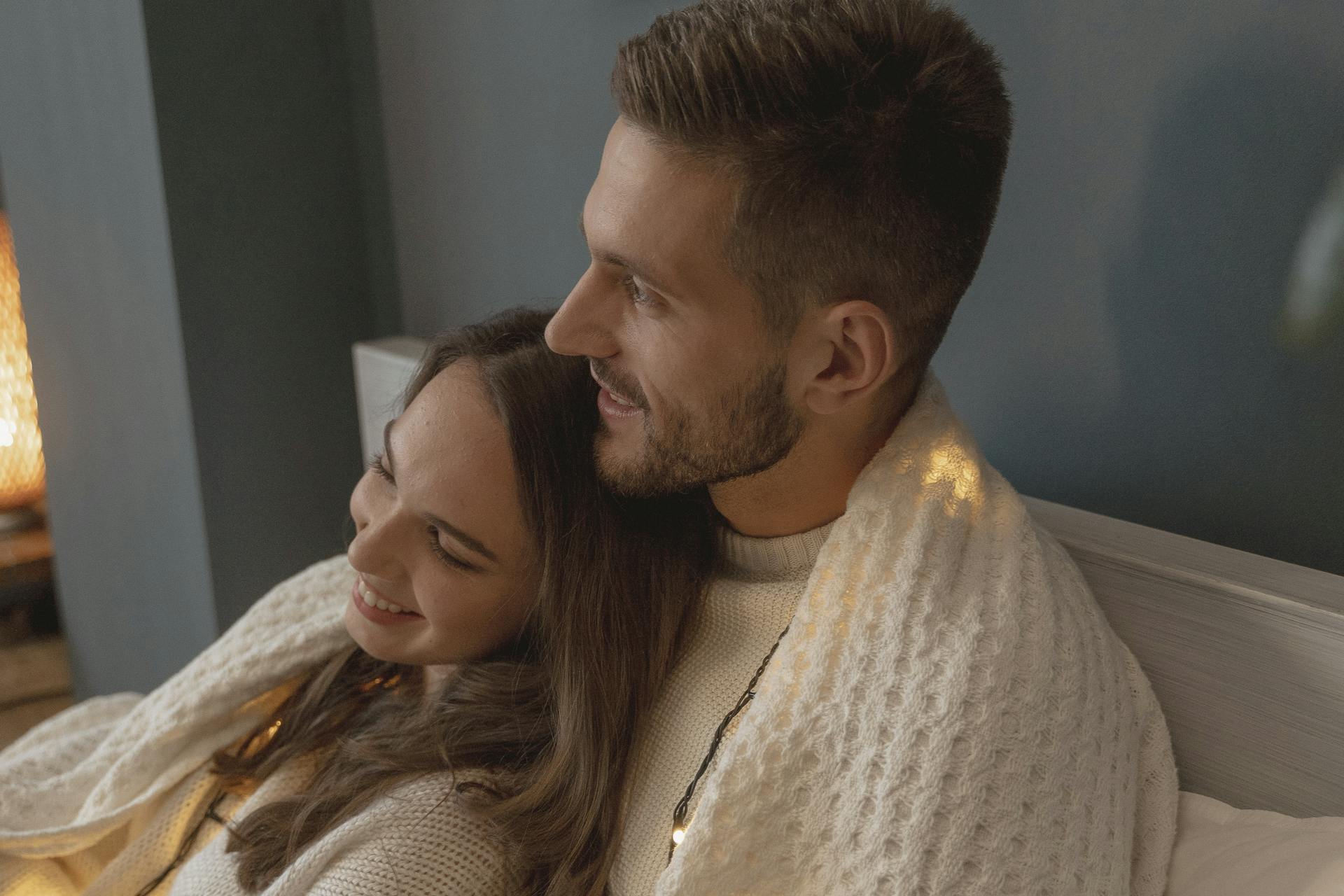 Gros plan d'un couple romantique se faisant des câlins au lit | Source : Pexels