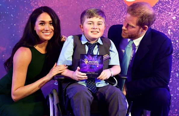 Le prince Harry, le duc de Sussex et Meghan, la duchesse de Sussex posent pour une photo avec le lauréat William Magee à l'occasion du WellChild Awards | Photo: Getty Images