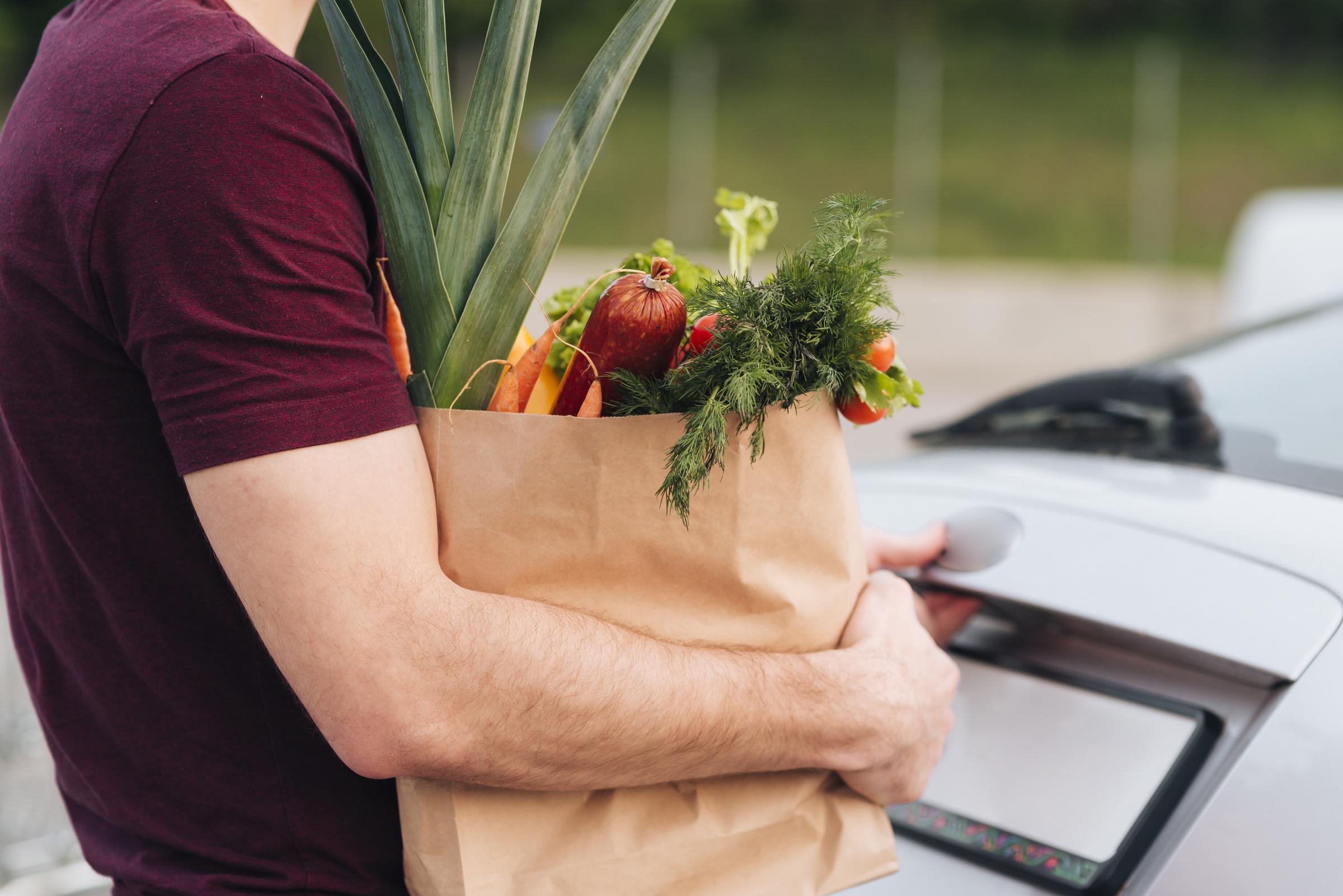 Homme tenant un sac d'épicerie | Source : Freepik