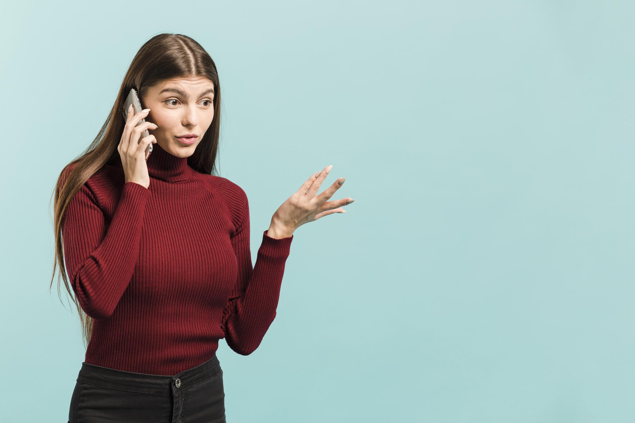 Une femme en train de téléphoner fait un geste de la main | Source : Freepik