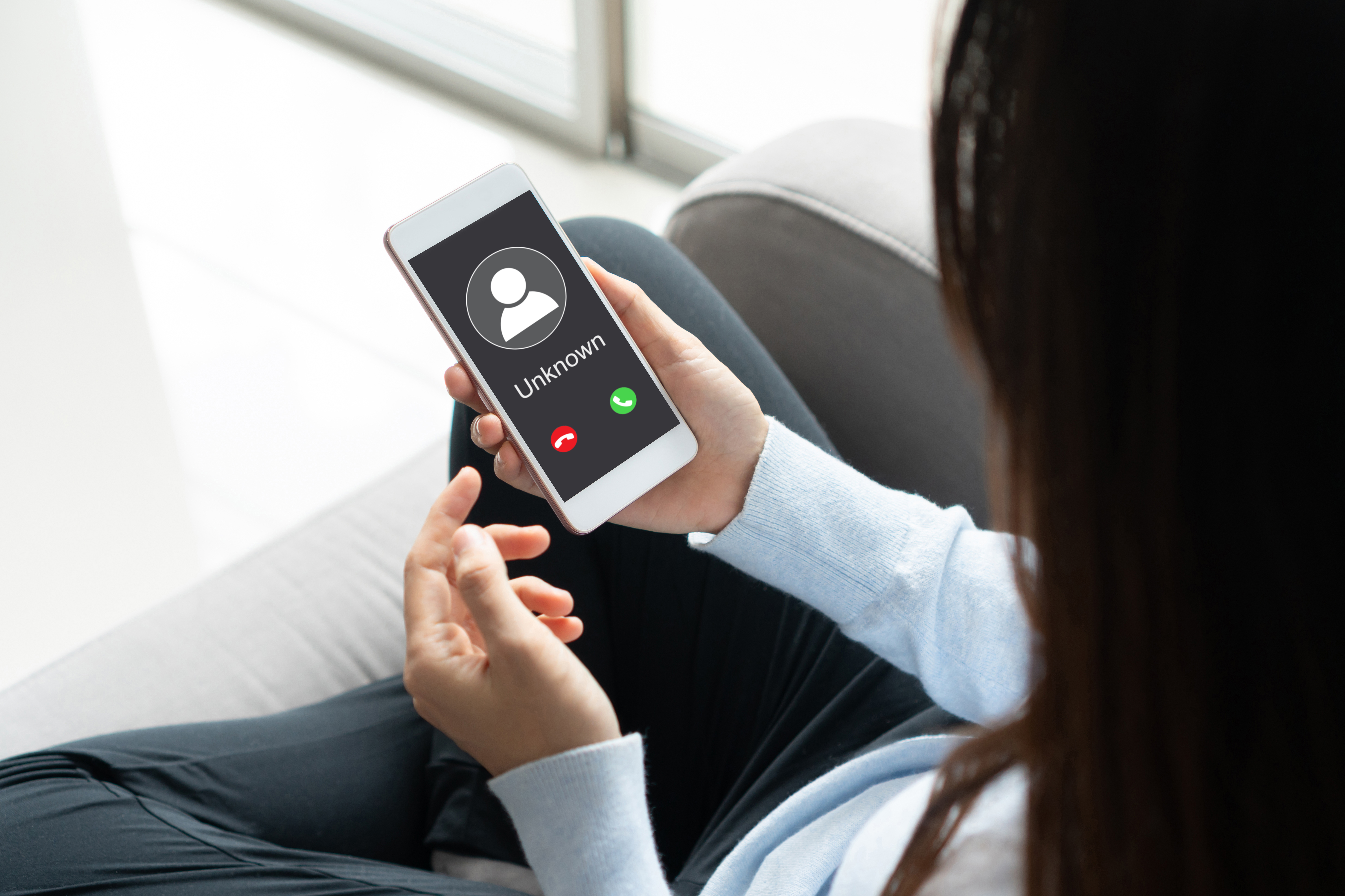 Une femme tient son téléphone dont l'écran affiche un appel entrant | Source : Getty Images