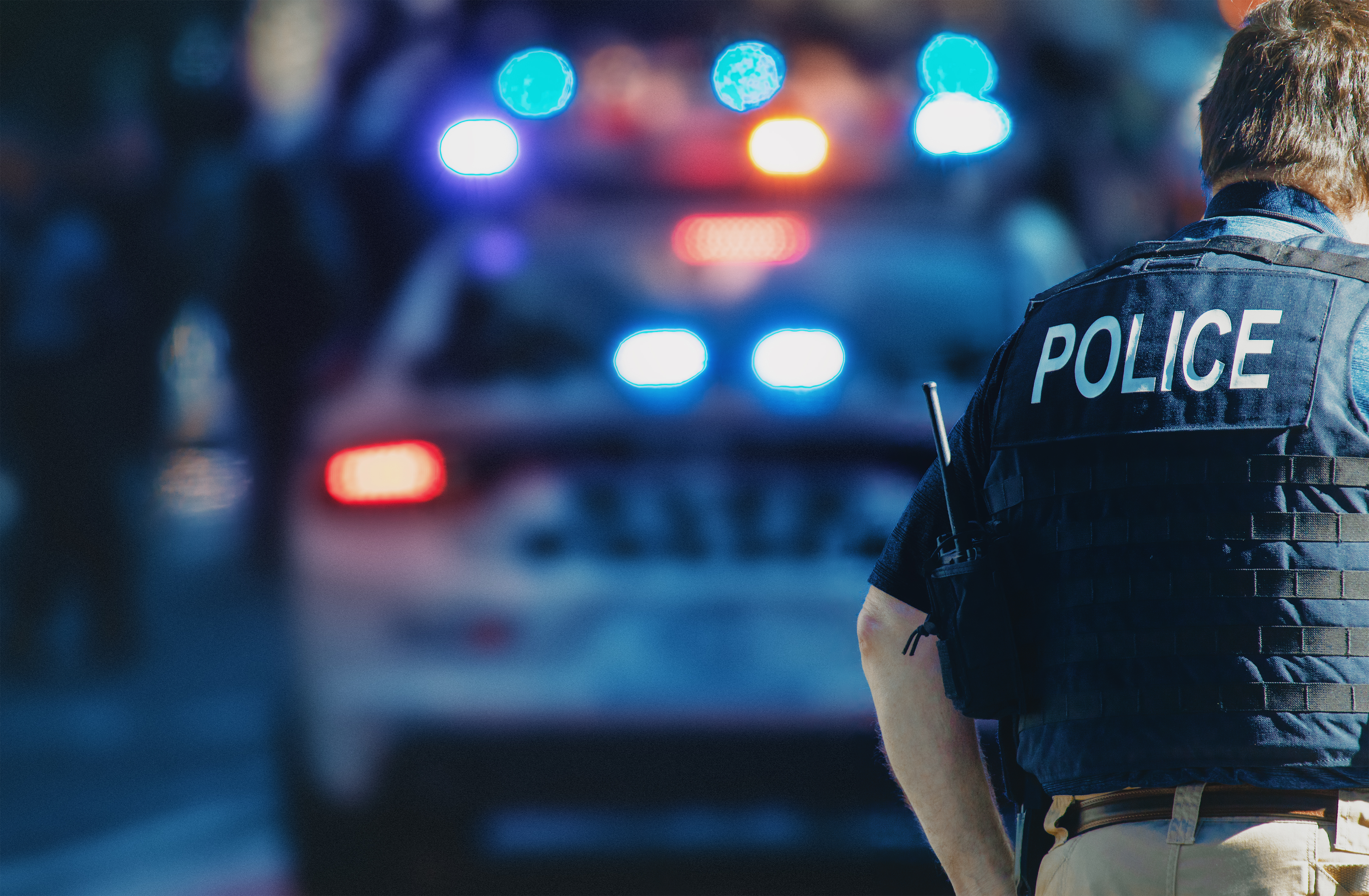 Un policier debout derrière une voiture de police | Source : Shutterstock