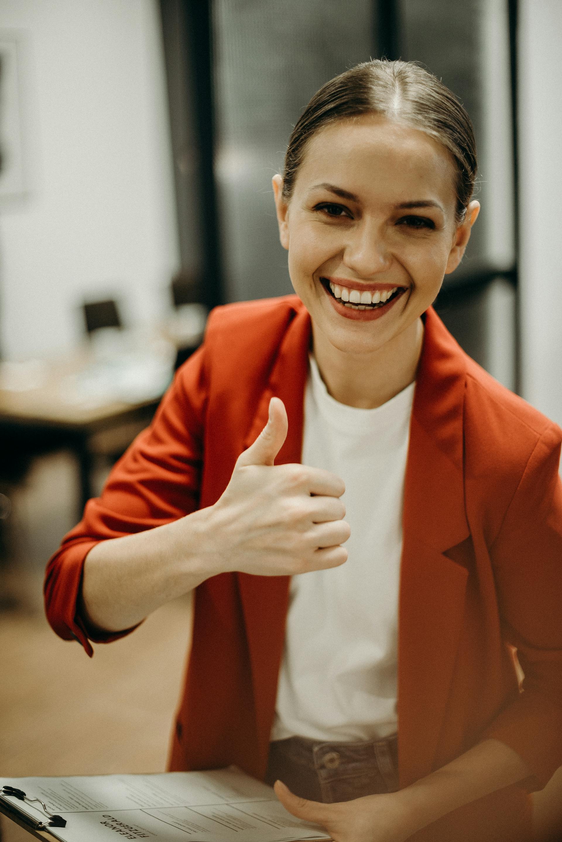 Une collègue féminine faisant le signe du pouce levé | Source : Pexels