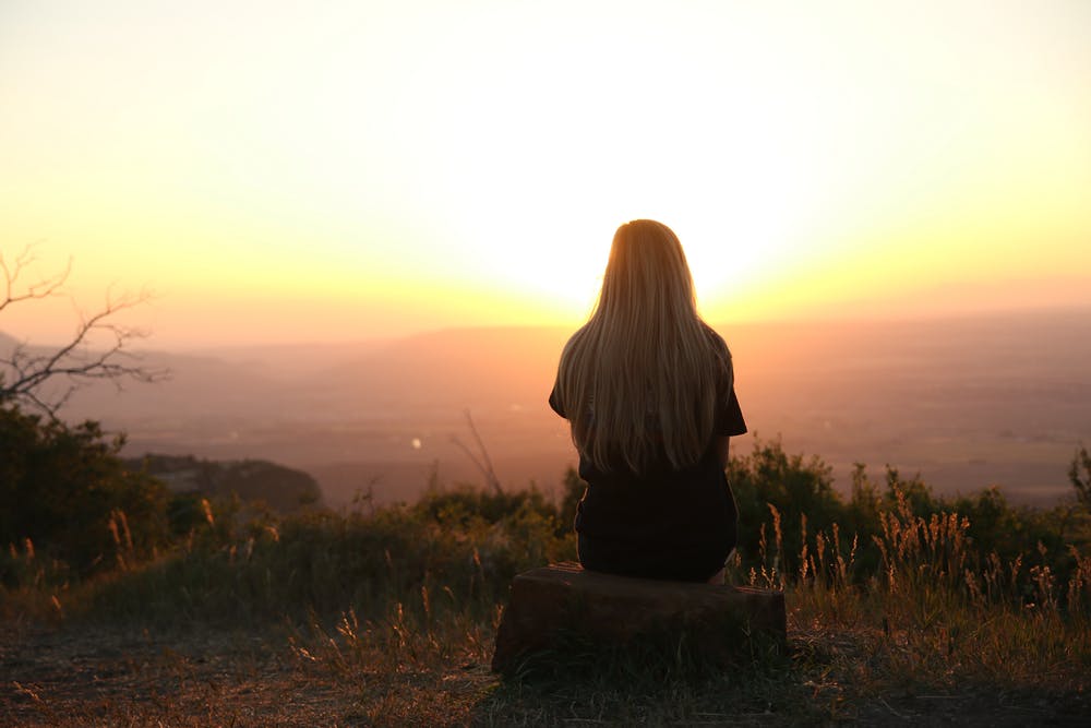 Une femme regardant le coucher du soleil | Source : Pexels