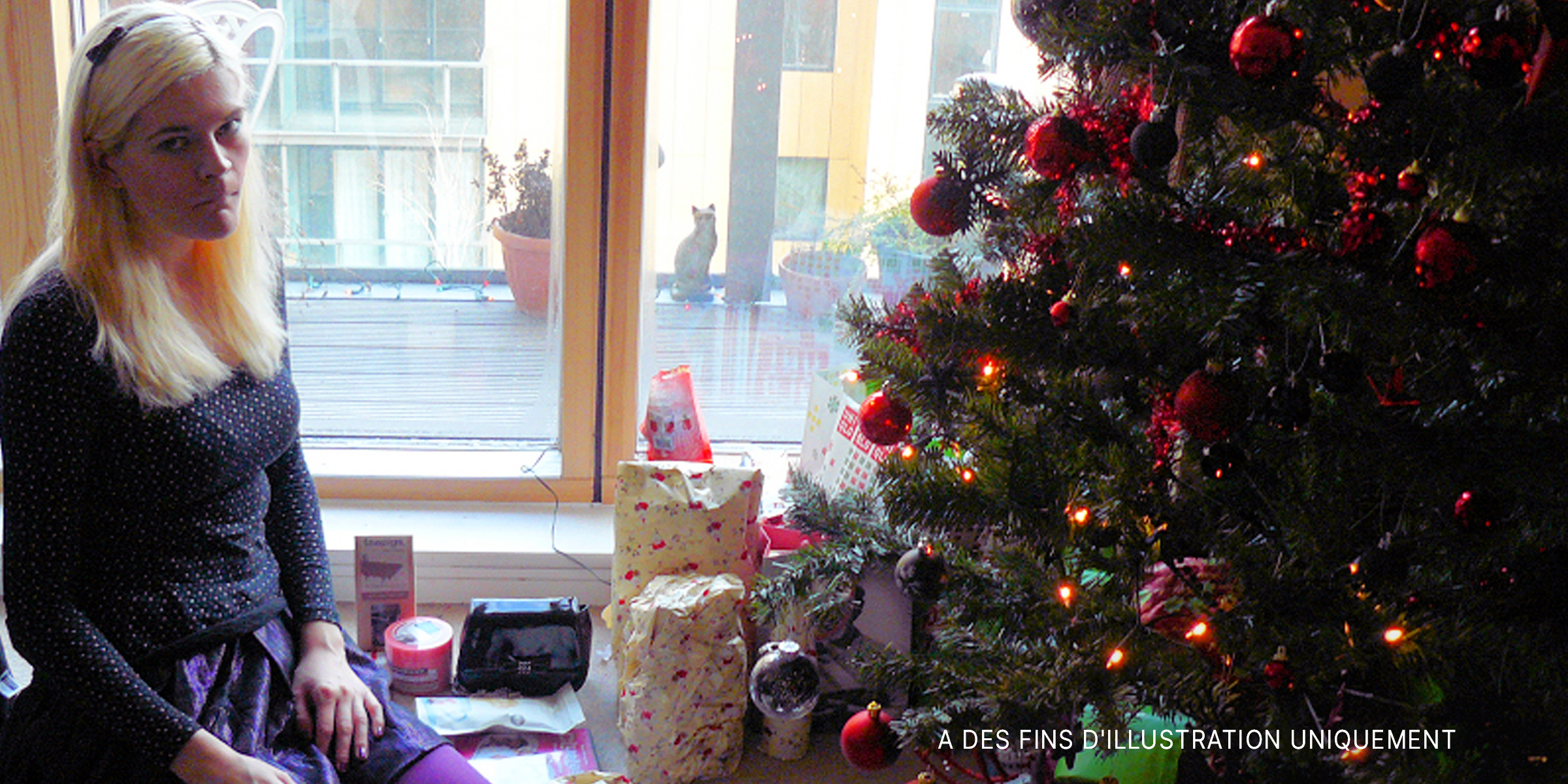 Une femme triste assise à côté d'un arbre de Noël | Source : Flickr.com/Mike_fleming/CC BY 2.0