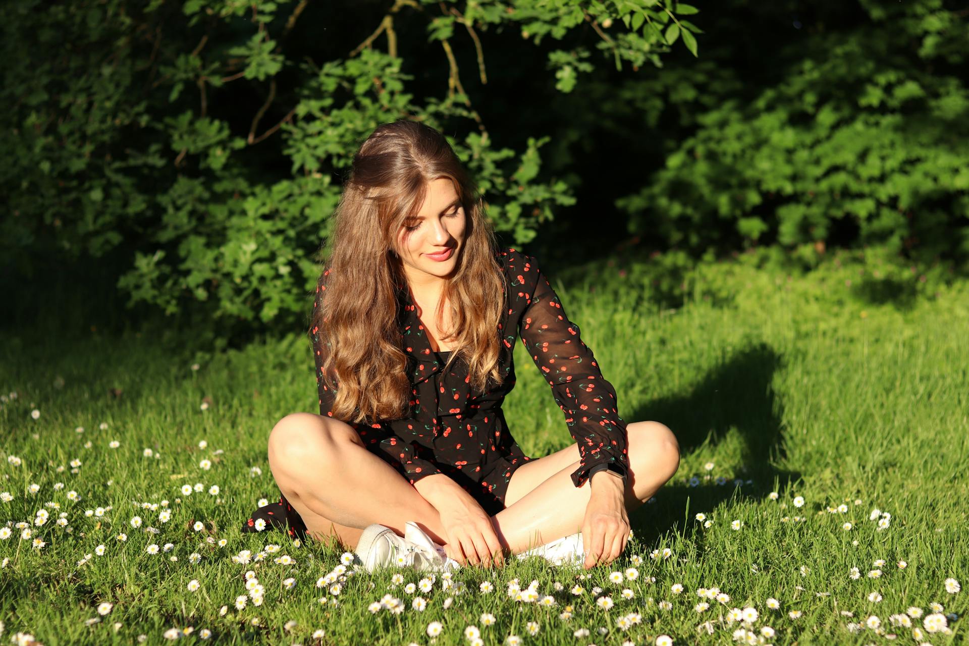 Une femme assise sur l'herbe | Source : Pexels