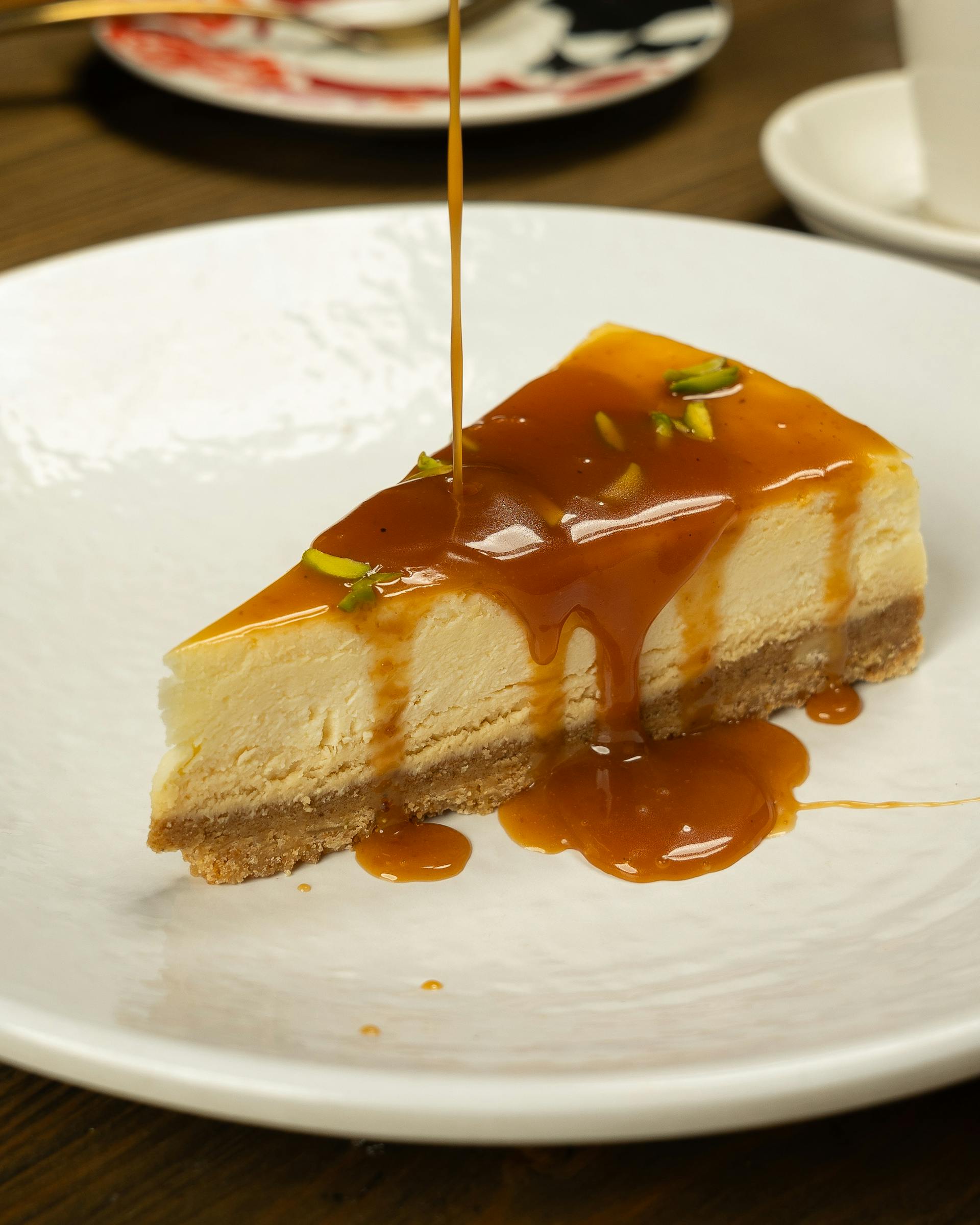 Une tranche de gâteau au fromage avec de la sauce au caramel arrosée sur le dessus | Source : Pexels