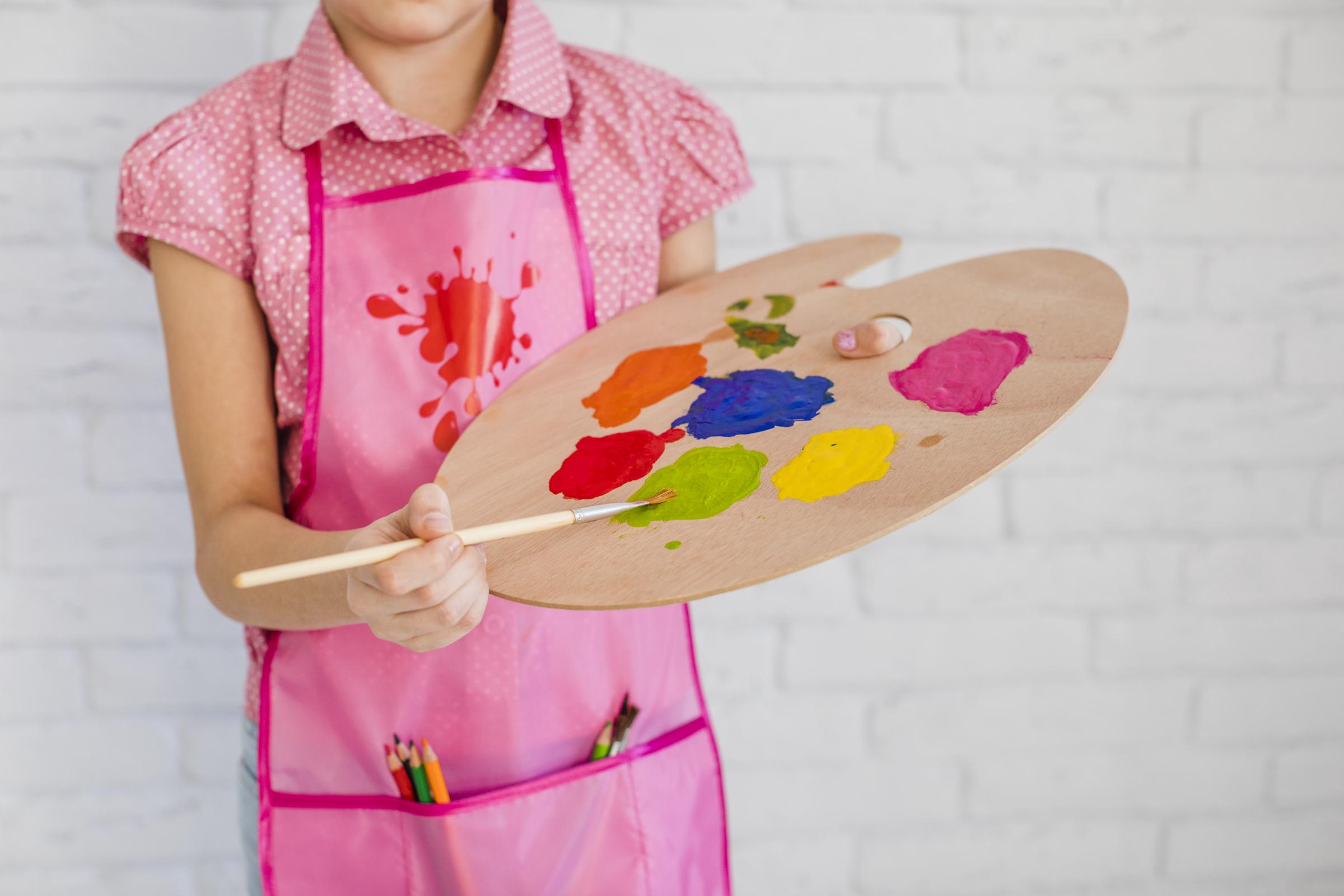 Un enfant tenant une palette de couleurs | Source : Freepik