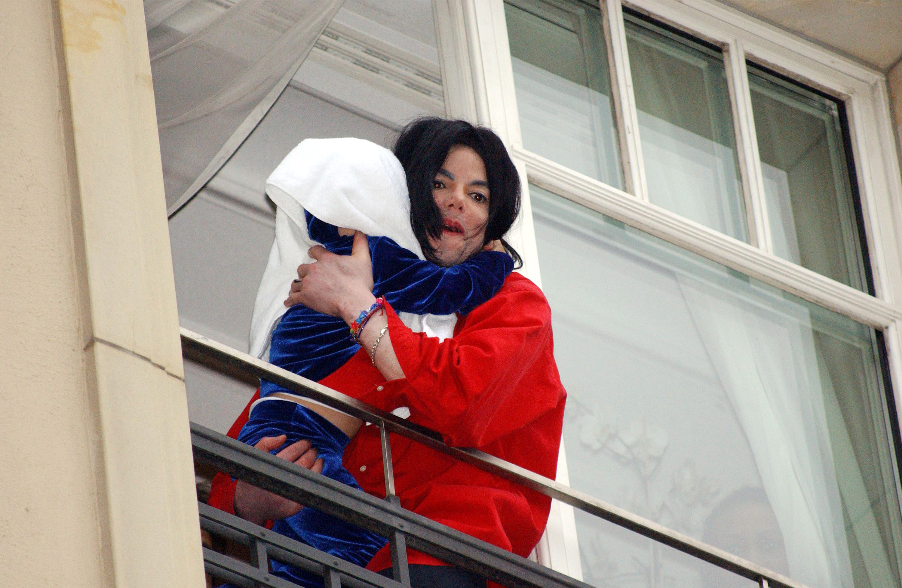 Michael Jackson tenant l'un de ses enfants sur un balcon de l'hôtel Adlon à Berlin en 2002 | Source : Getty Images