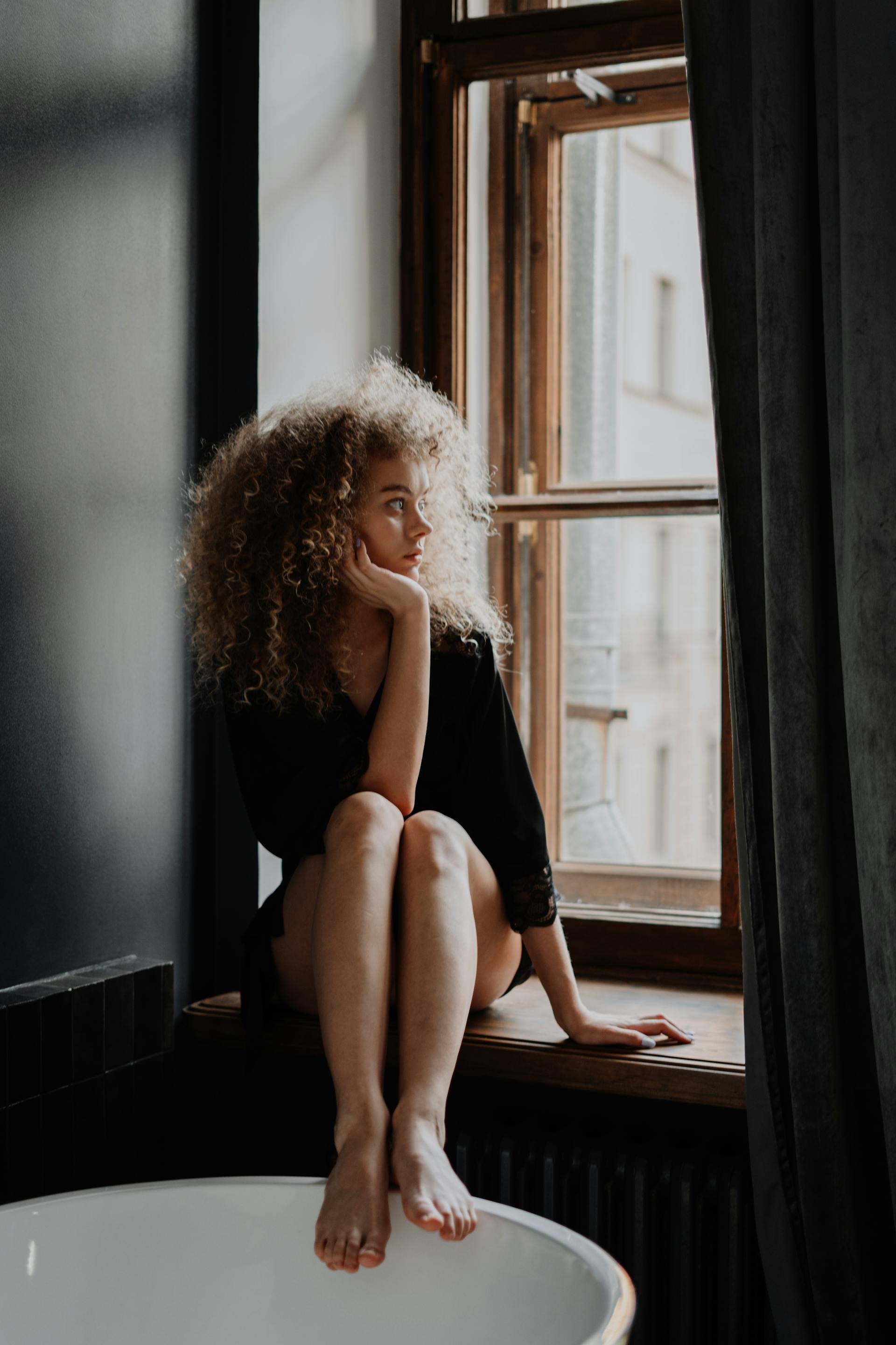 Une femme qui regarde par la fenêtre | Source : Pexels