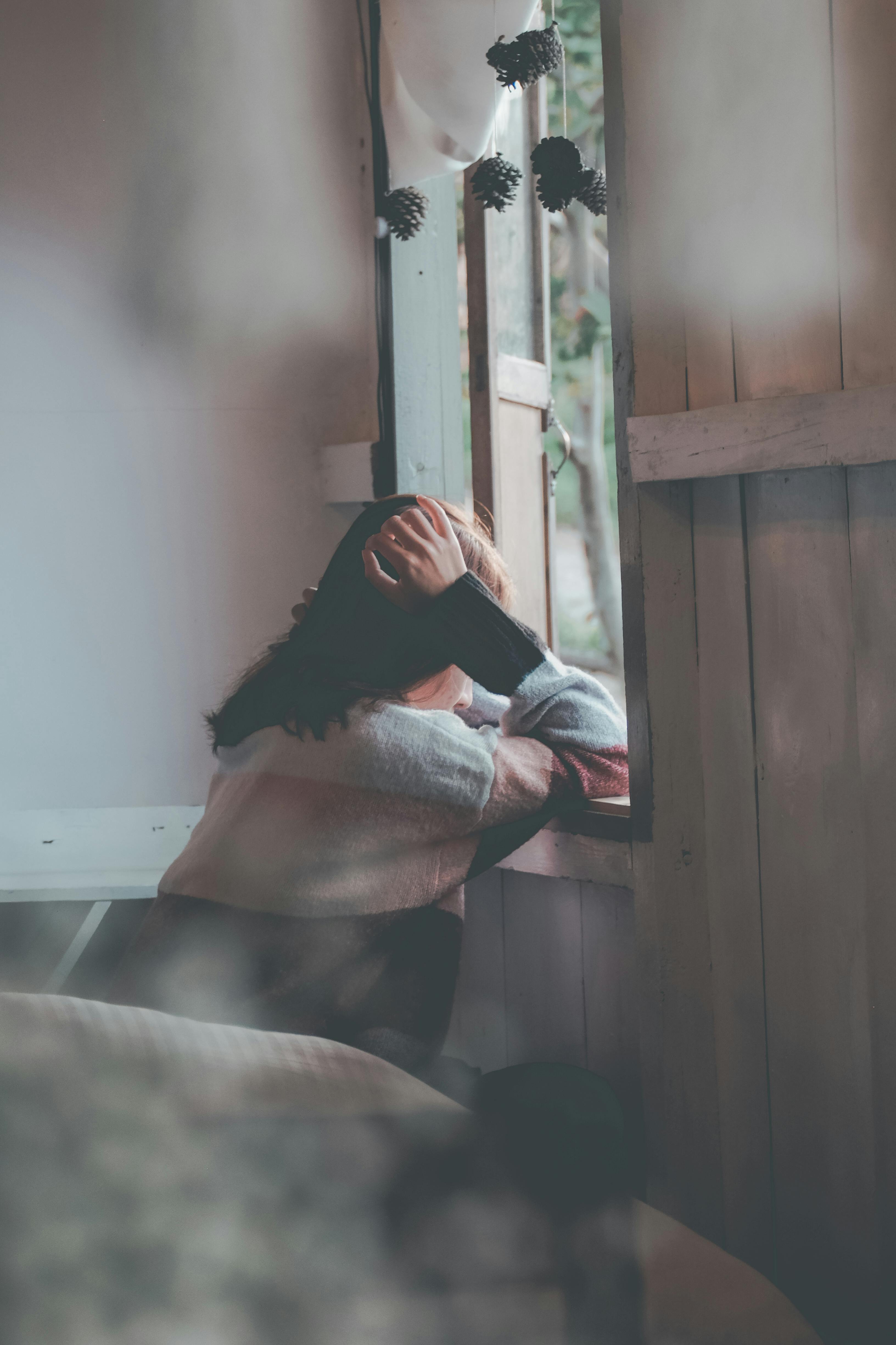 Une femme triste qui regarde par la fenêtre | Source : Pexels