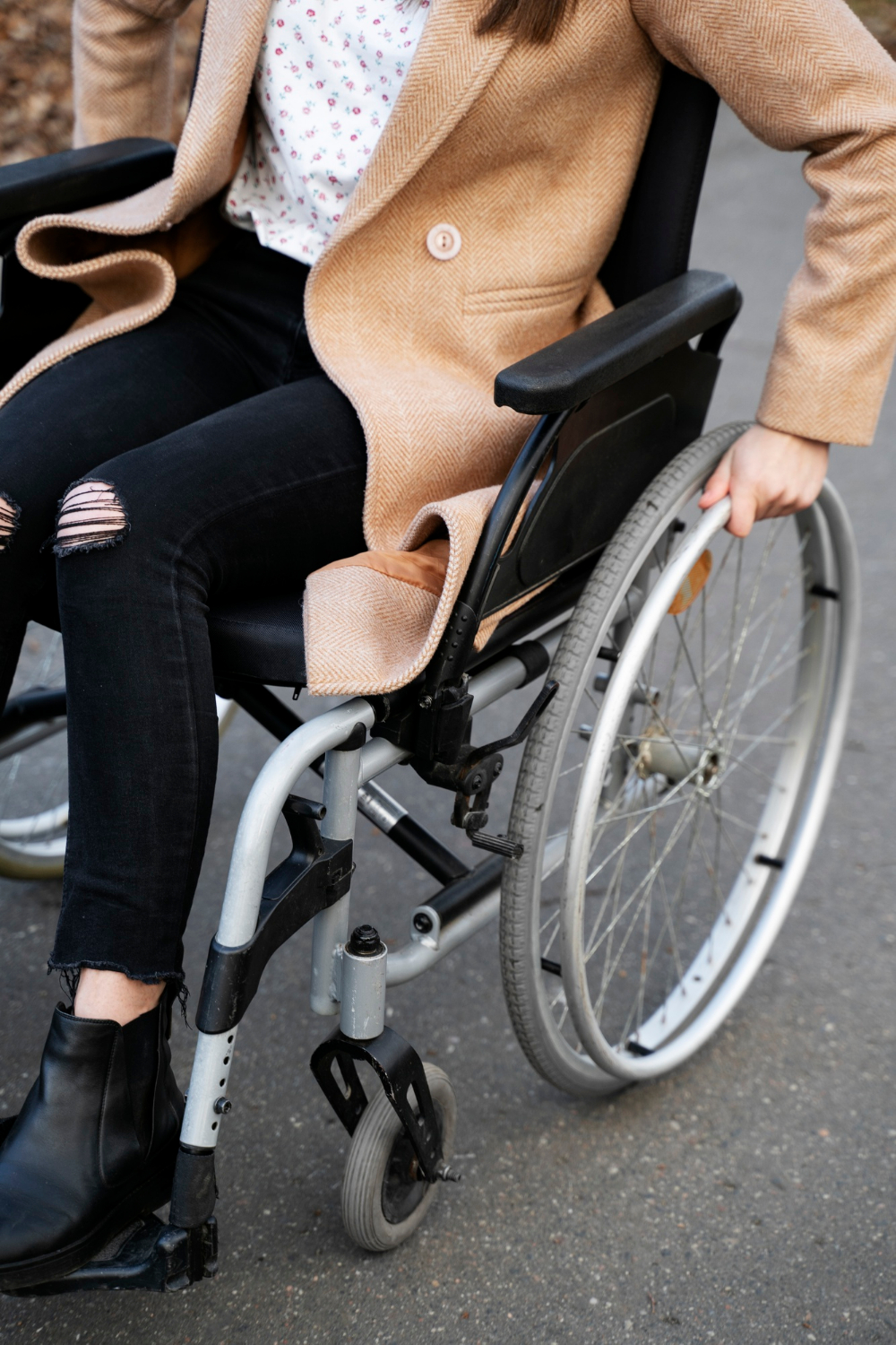 Une femme assise sur son fauteuil roulant et naviguant vers l'avant | Source : Freepik
