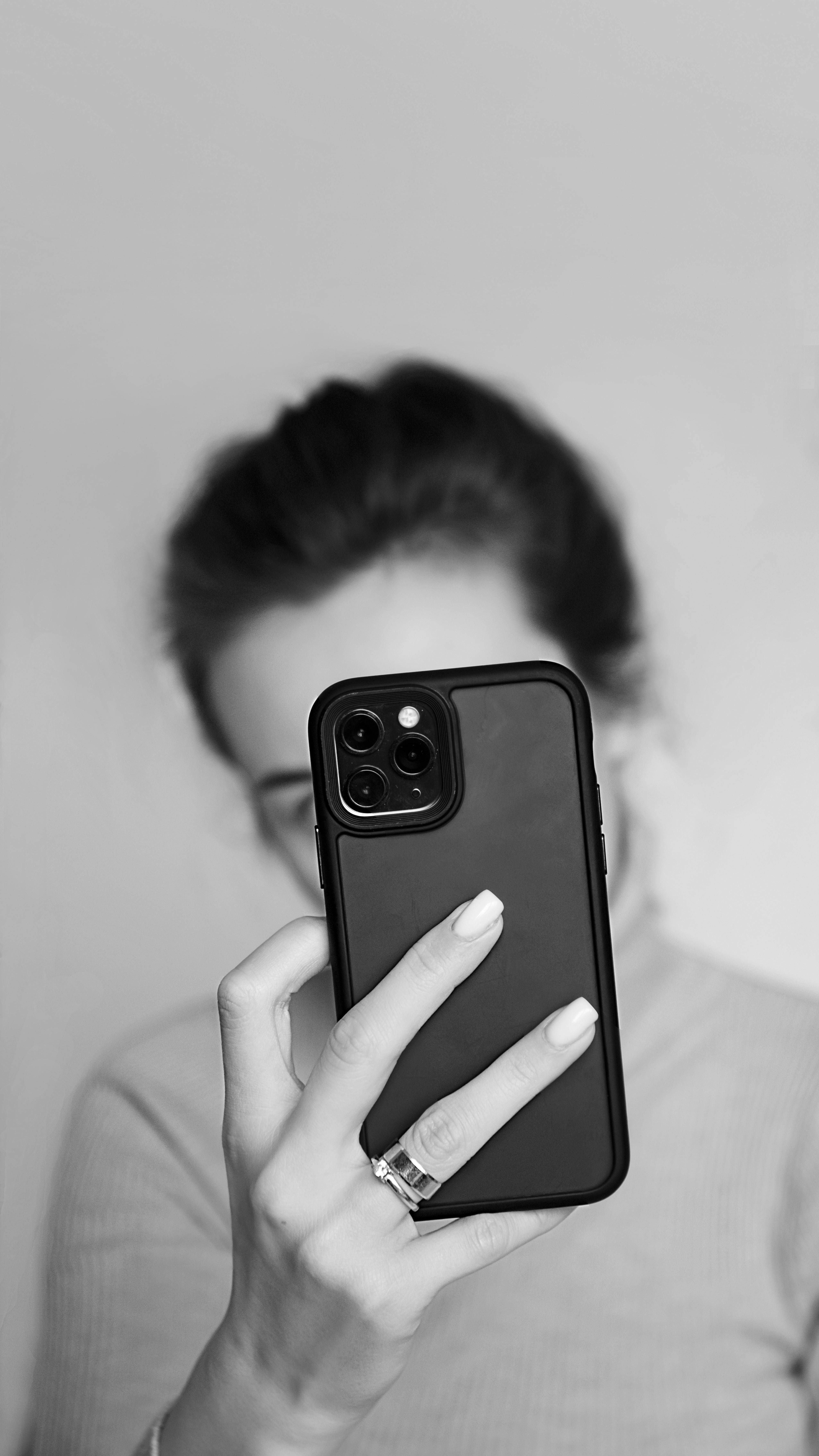 Une femme cachant son visage avec son téléphone | Source : Pexels