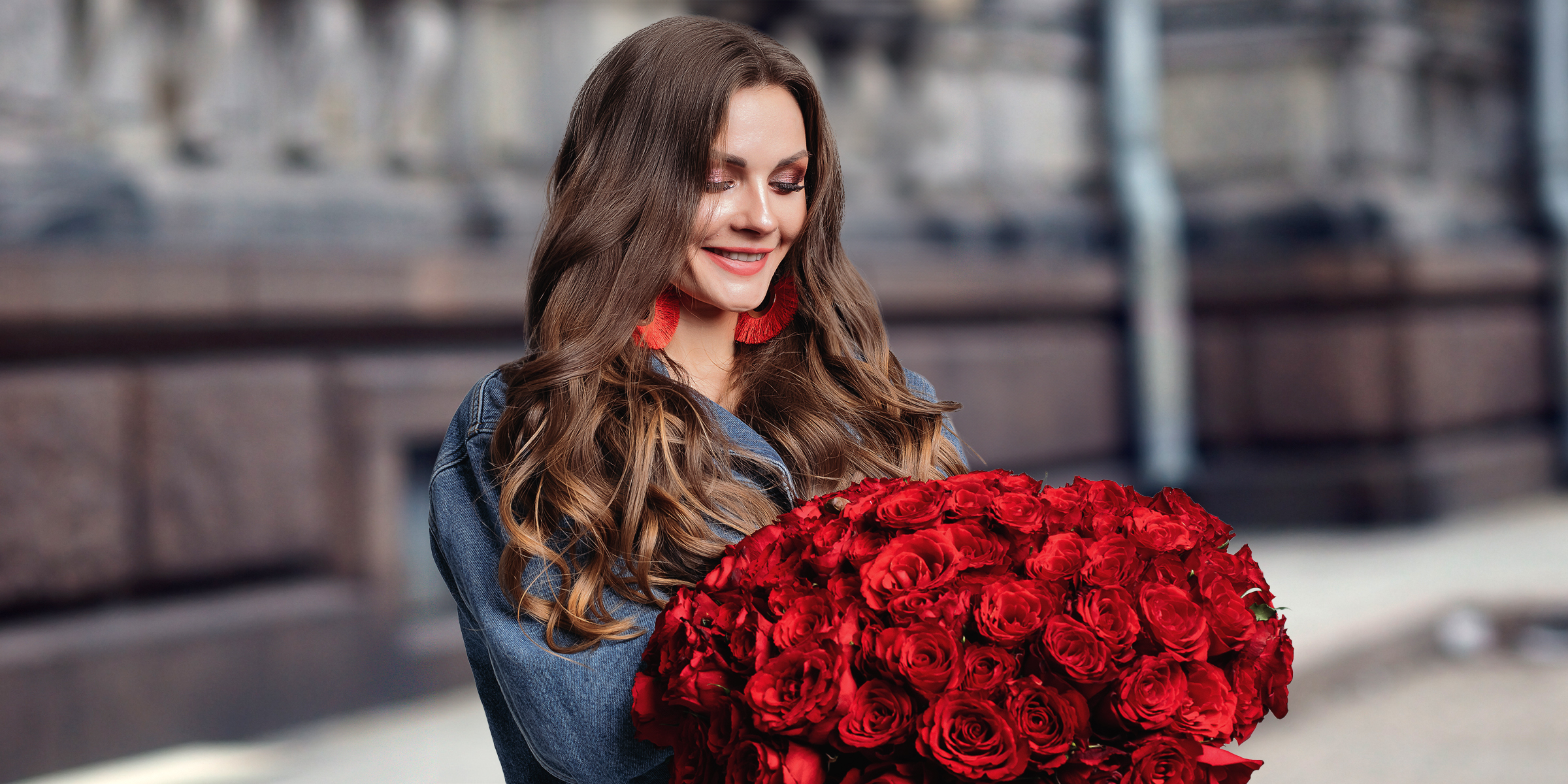 Une femme heureuse tenant un bouquet de roses rouges | Source : Shutterstock