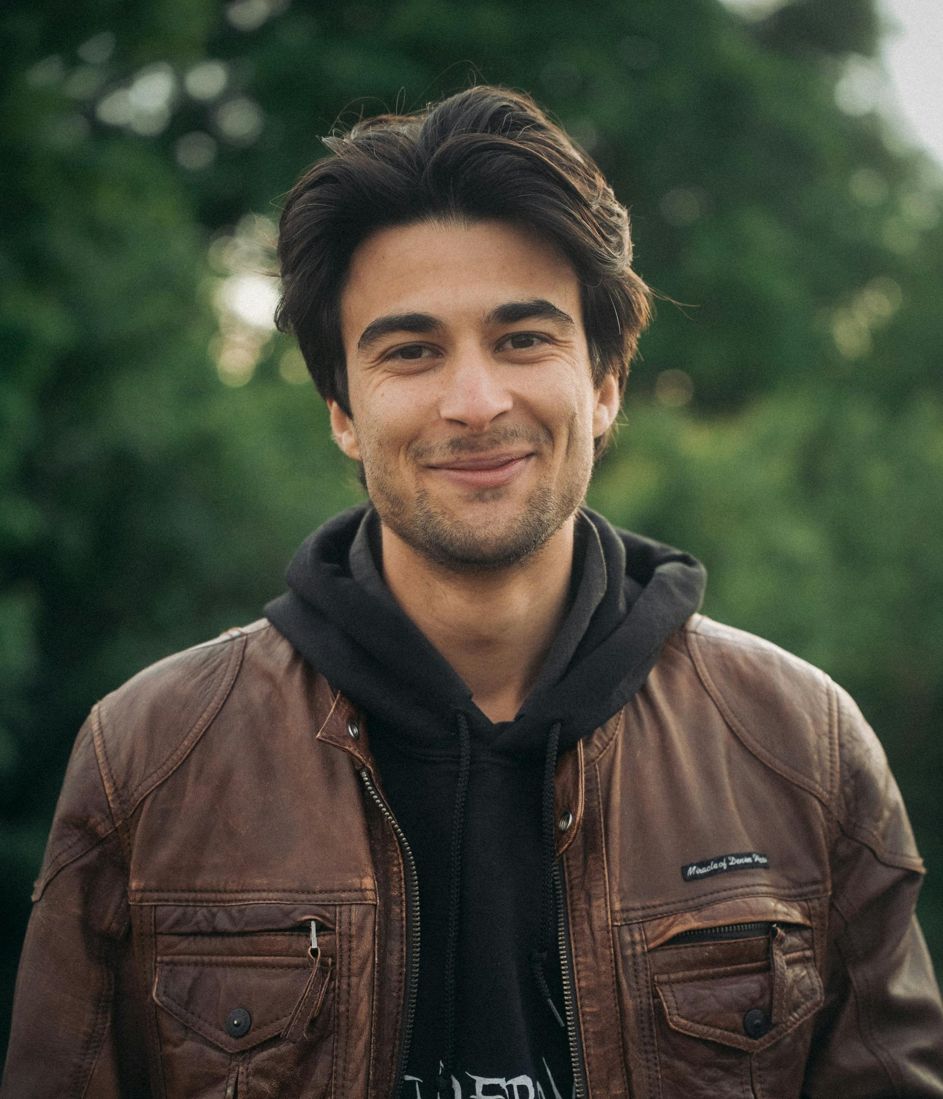 Un homme souriant avec un sweat à capuche | Source : Pexels
