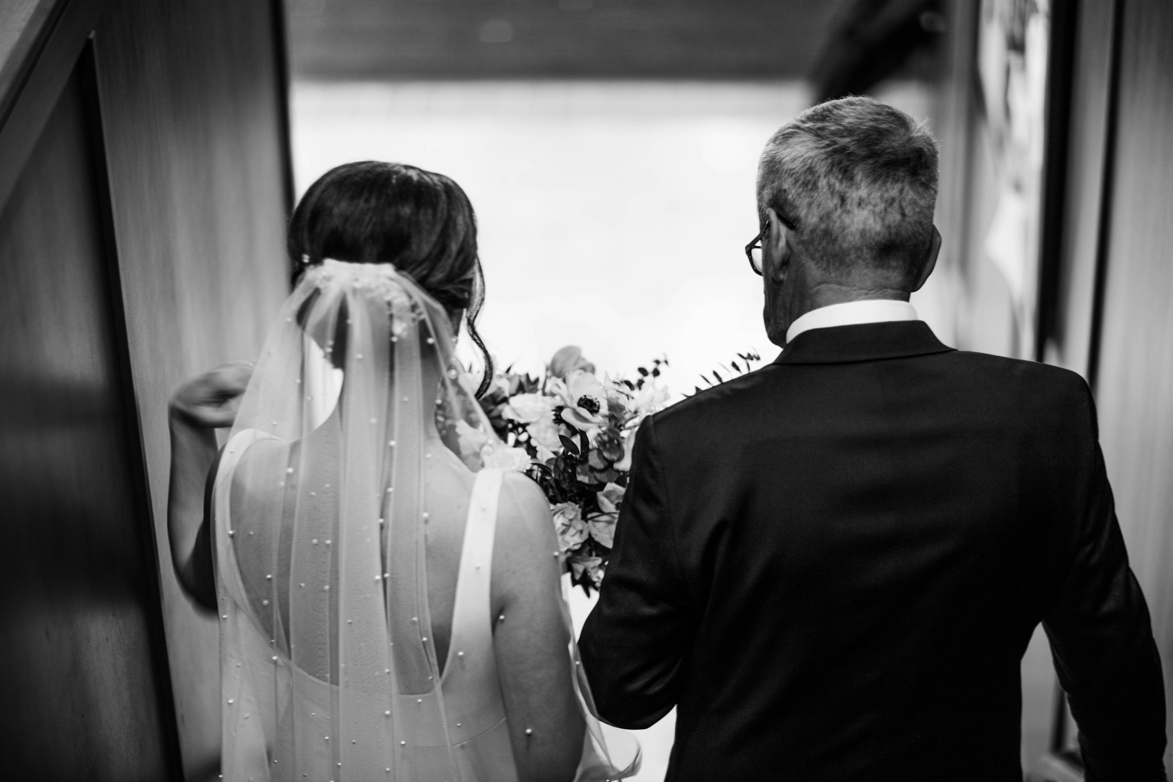 Un père et sa fiancée marchant dans un couloir | Source : Unsplash