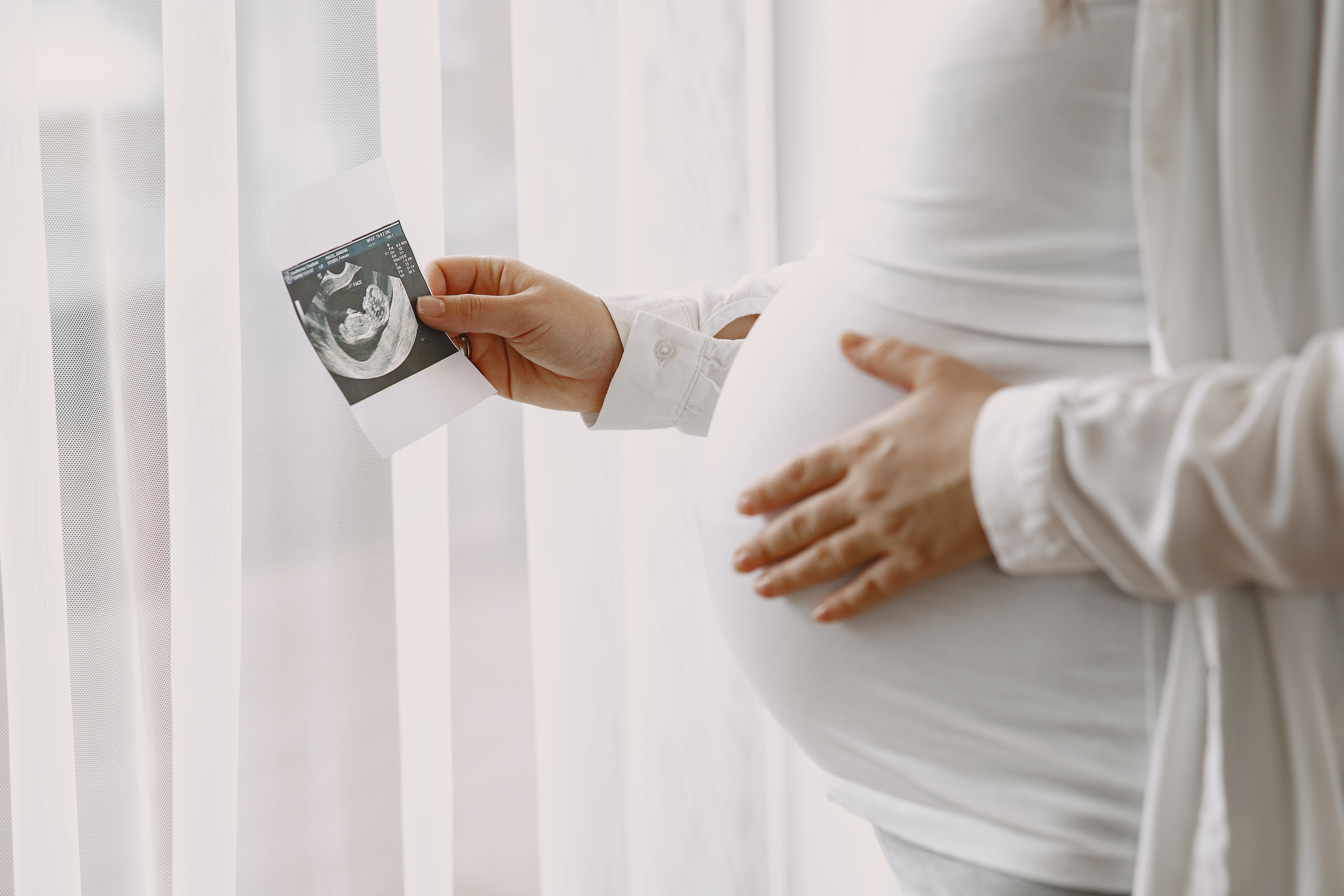 Une femme enceinte regardant une image de sonogramme de son bébé. À des fins d'illustration uniquement | Source : Freepik