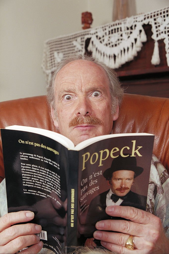 Le comédien Popeck lit une BD | photo : Getty Images