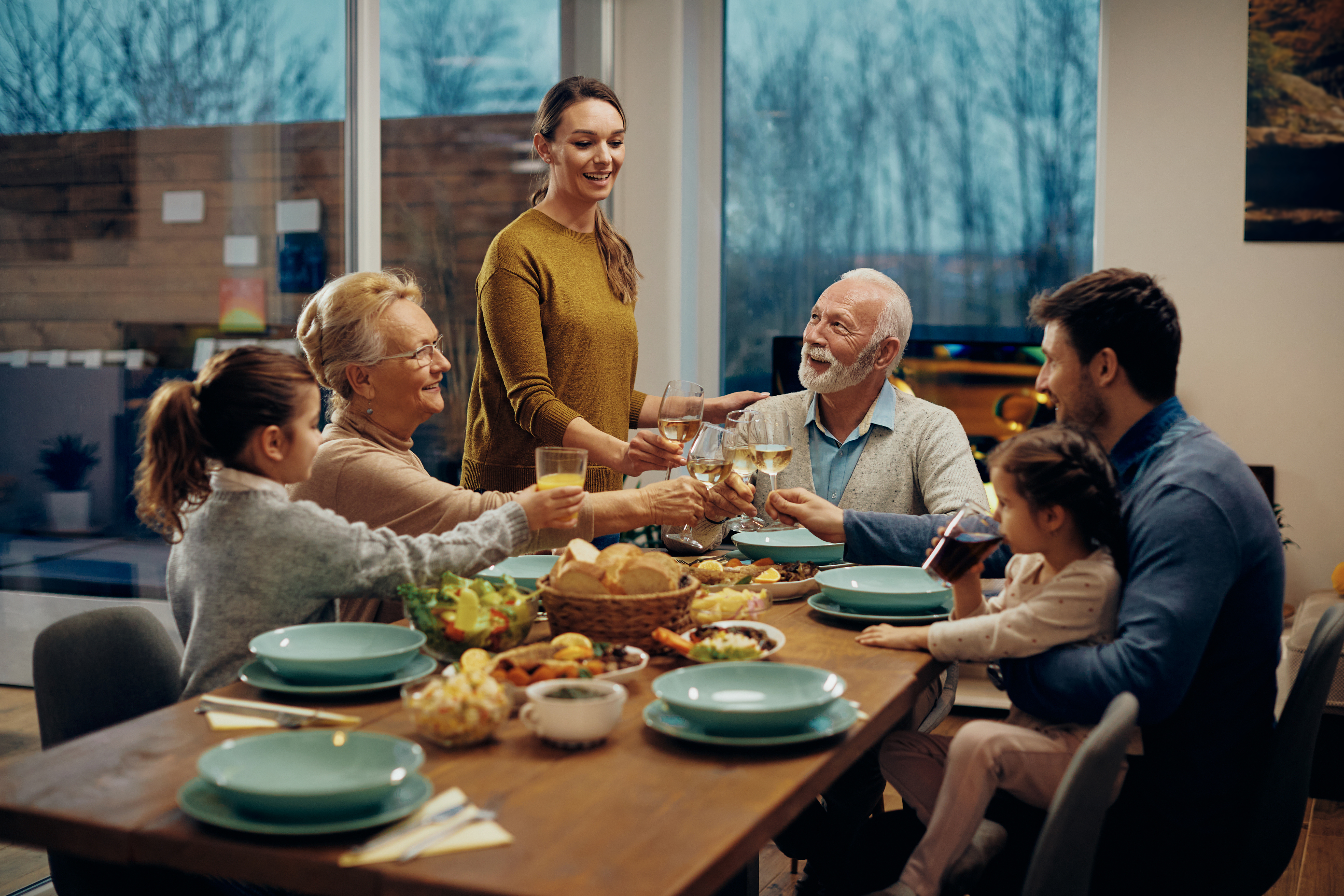 Une famille élargie heureuse qui porte un toast en dînant : Shutterstock