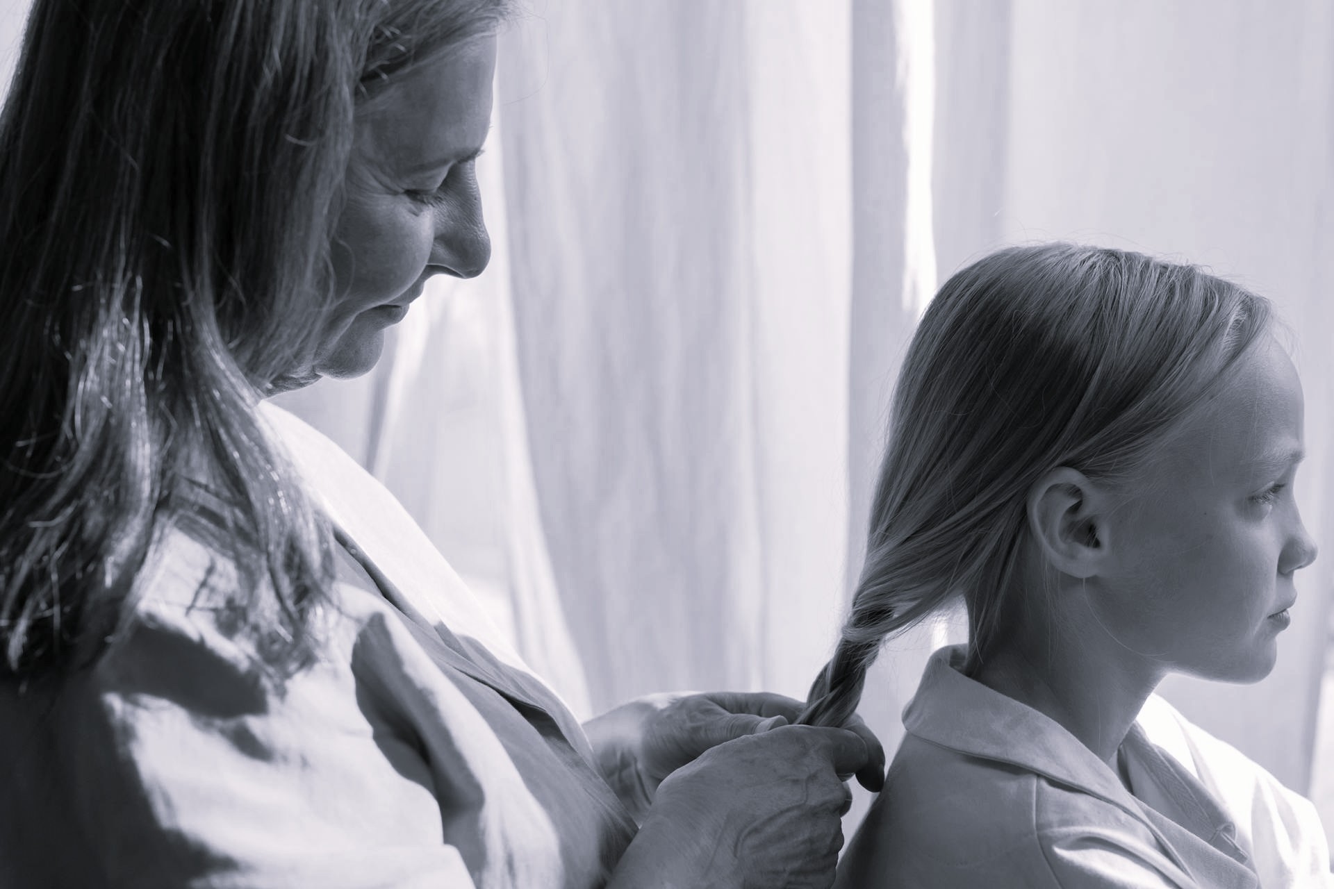 Une grand-mère tressant les cheveux de sa petite-fille | Source : Pexels