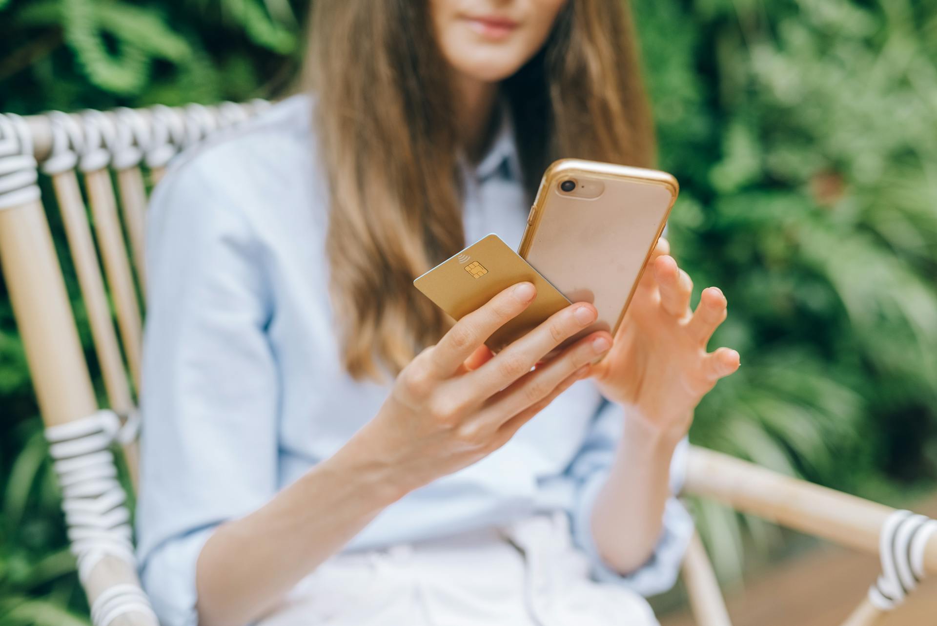 Une femme tenant un smartphone et une carte de crédit | Source : Pexels