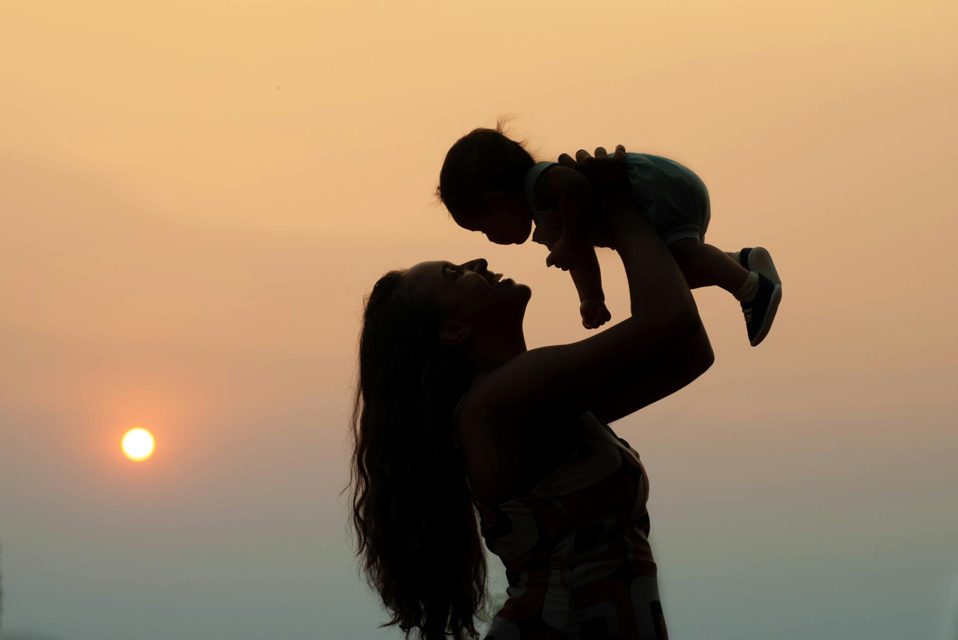 Silhouette d'une femme portant un bébé | Source : Pexels