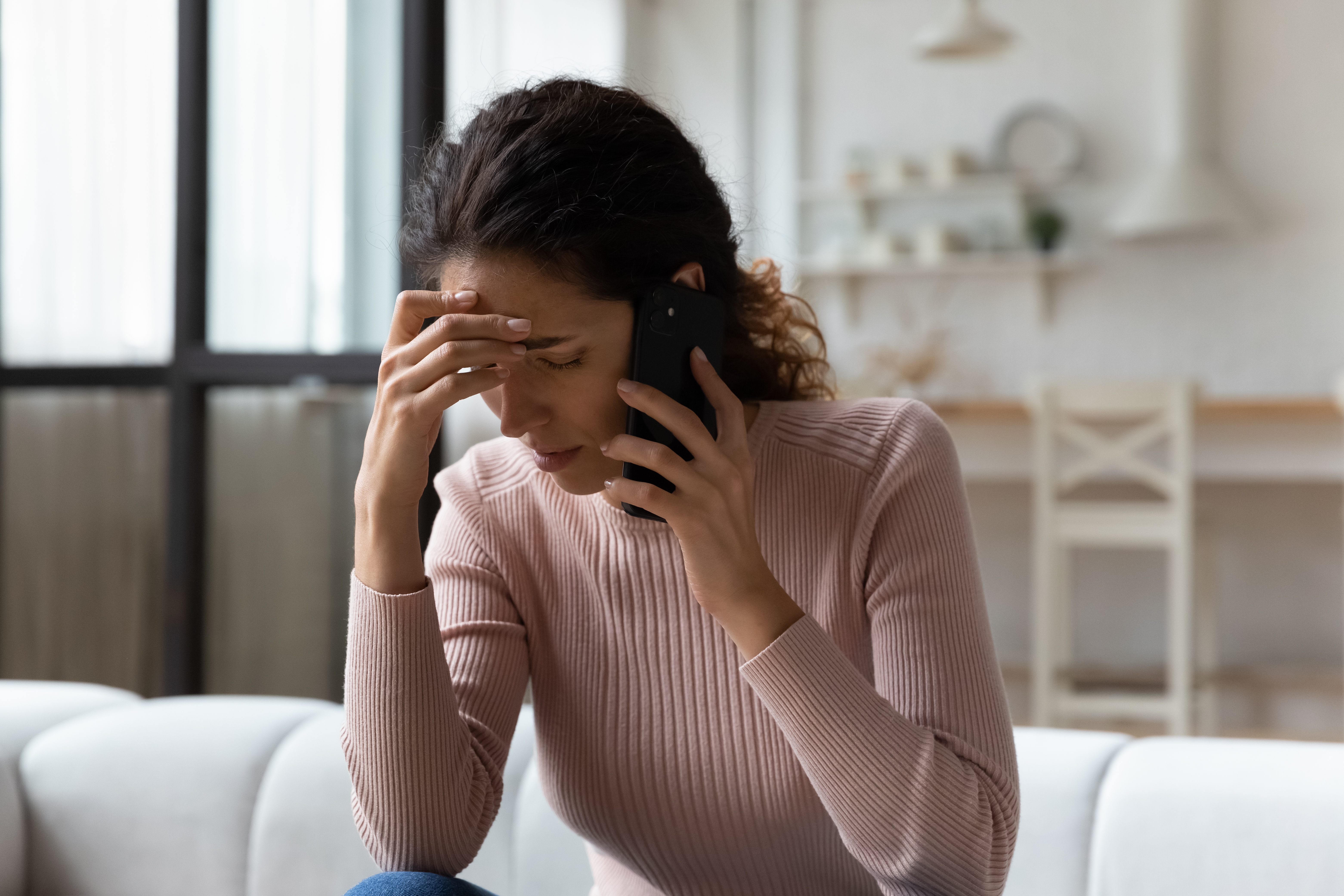 Femme inquiète parlant au téléphone | Source : Shutterstock