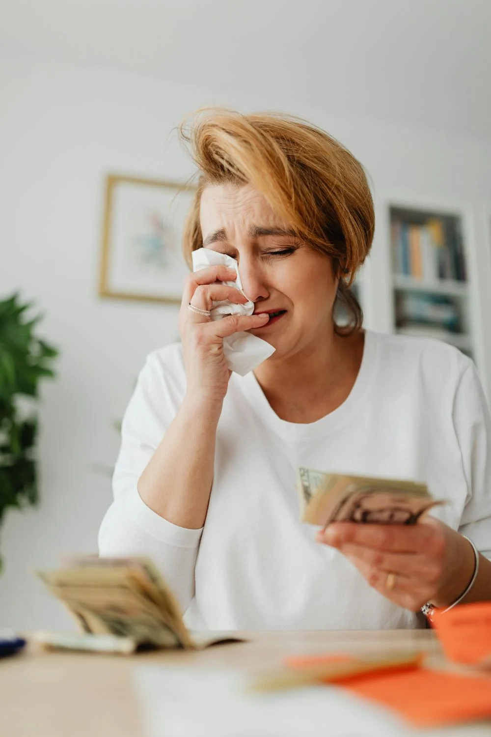 Une femme qui pleure en tenant de l'argent | Source : Pexels