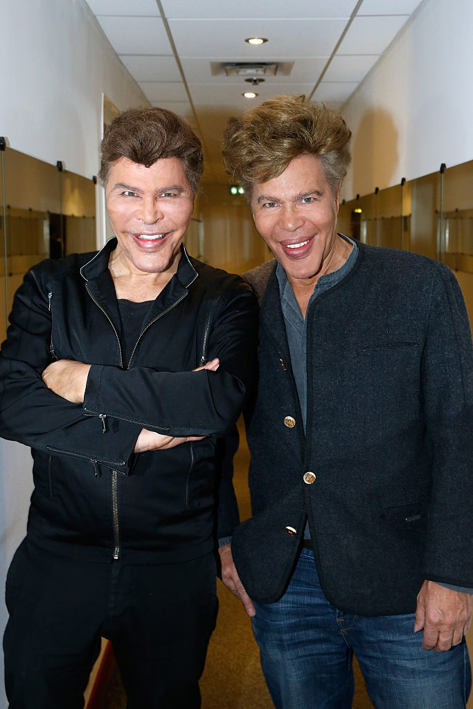 Grichka Bogdanov et son frère Igor Bogdanov présentent leur spectacle « Big Bang », joué au Théâtre du Gymnase, et leur livre « Le code secret de l'Univers » lors de l'émission télévisée française « Vivement Dimanche » au Pavillon Gabriel le 16 décembre 2015 à Paris, France. | Source : Getty Images