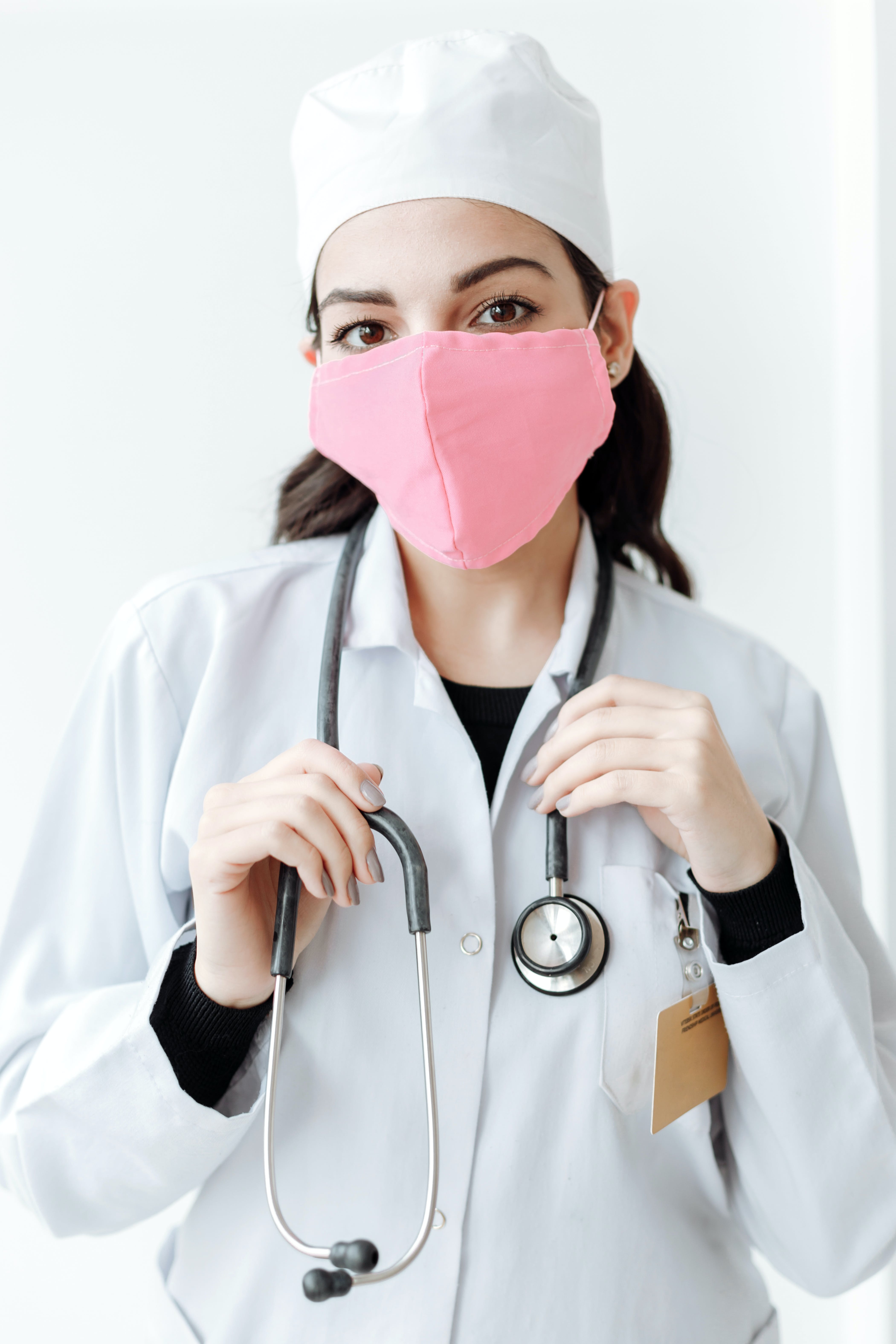 Una doctora con una mascarilla rosa. | Fuente: Pexels