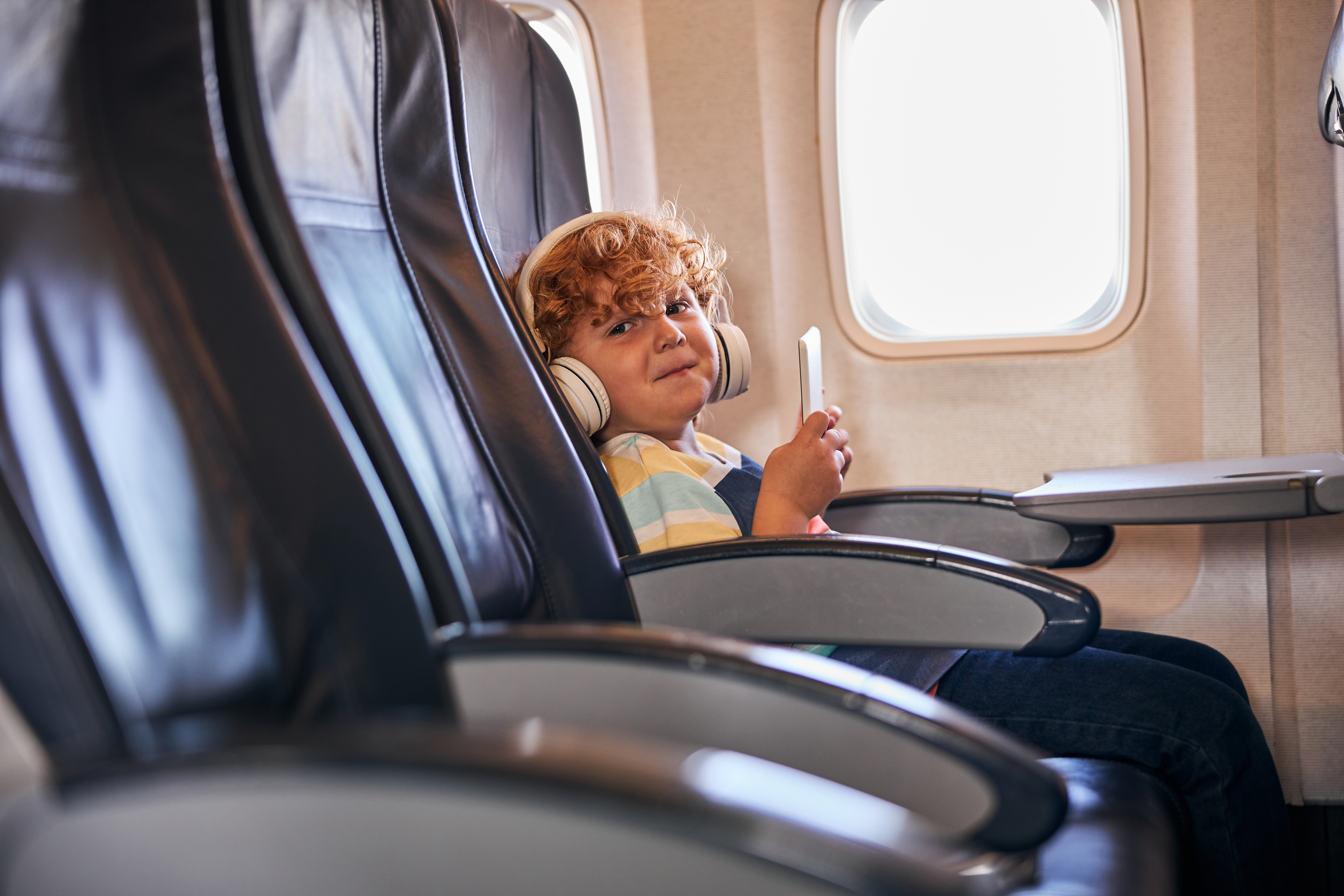 Un enfant malicieux dans un avion | Source : Shutterstock