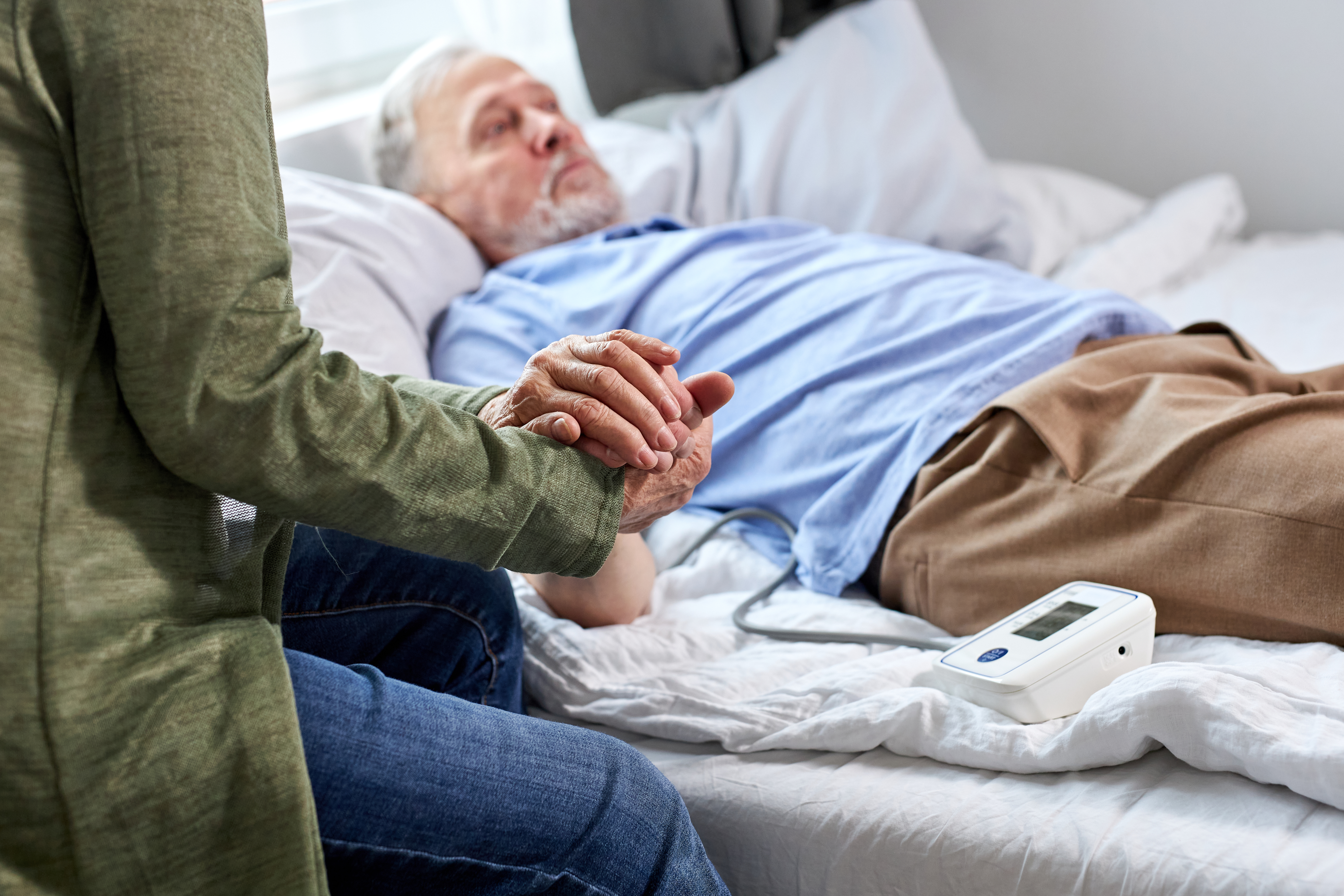 Une femme tenant la main d'un homme âgé souffrant | Source : Shutterstock