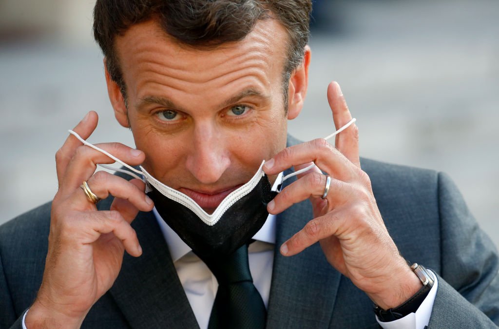 Emmanuel Macron enlevant son masque. | Photo : Getty Images