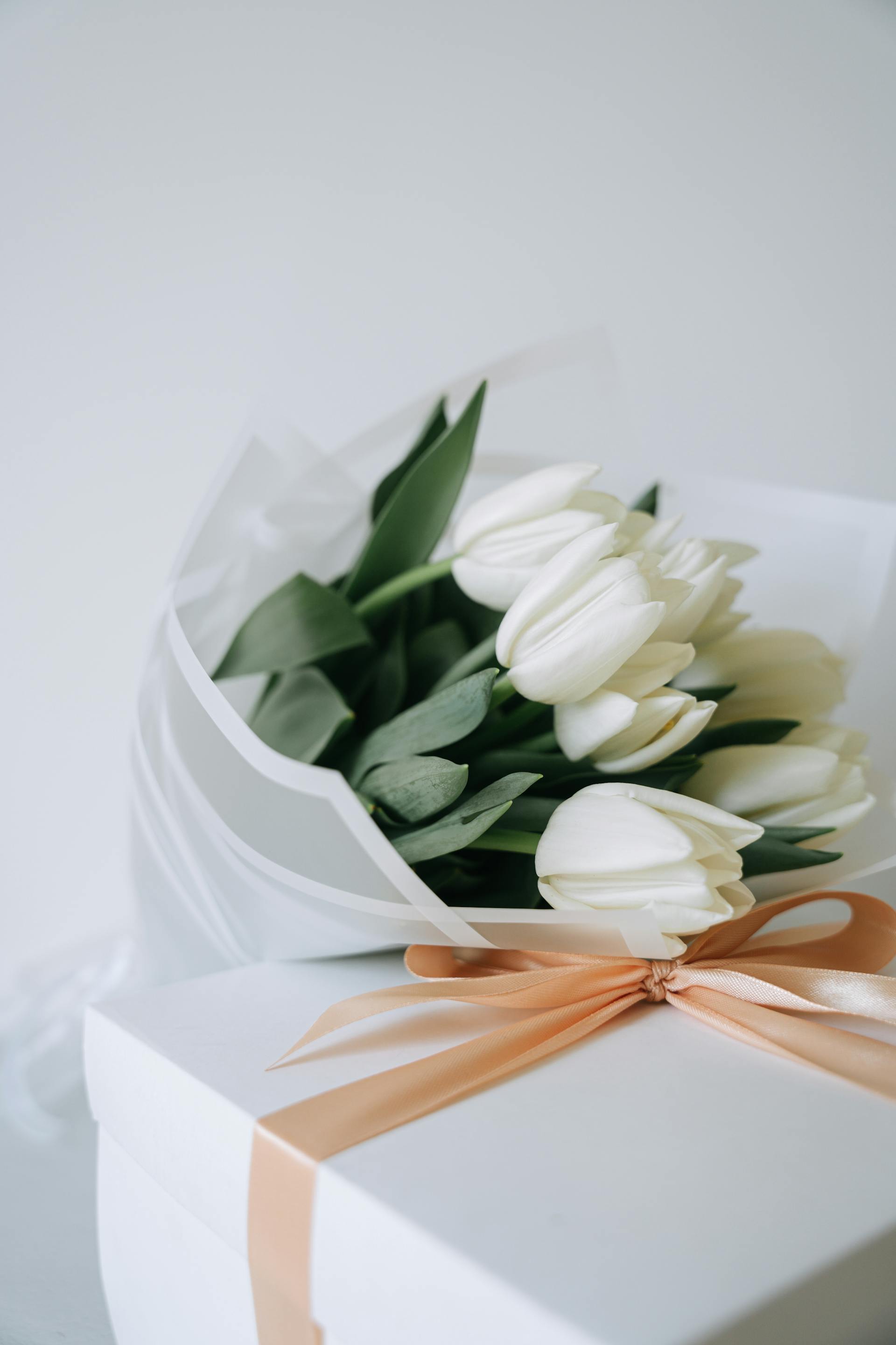 Un bouquet de tulipes blanches et un paquet cadeau | Source : Pexels